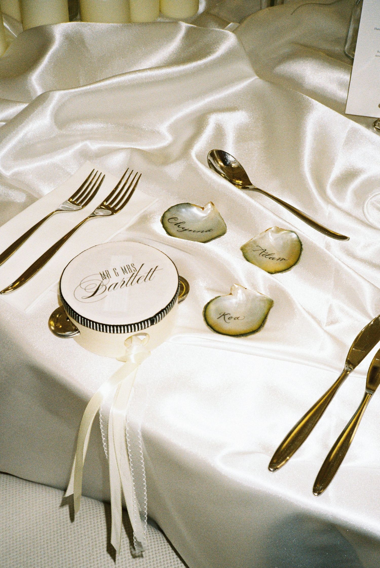Elegant table settings with white linens and formal silverware arranged in a minimalist style.