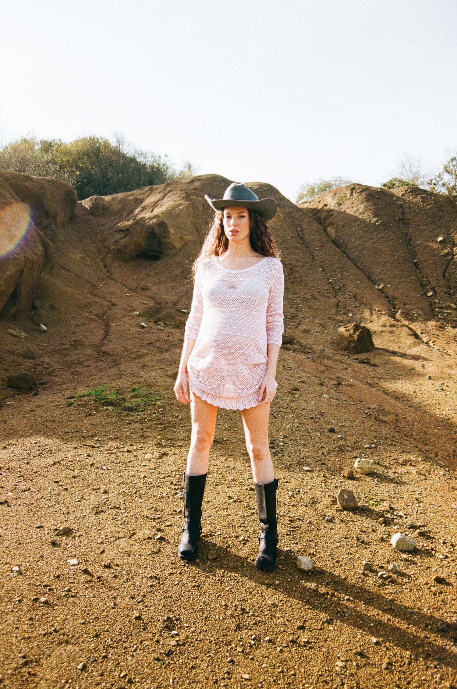 Series of photos on dusty terrain showing white lace dress and black boots with long shadows.