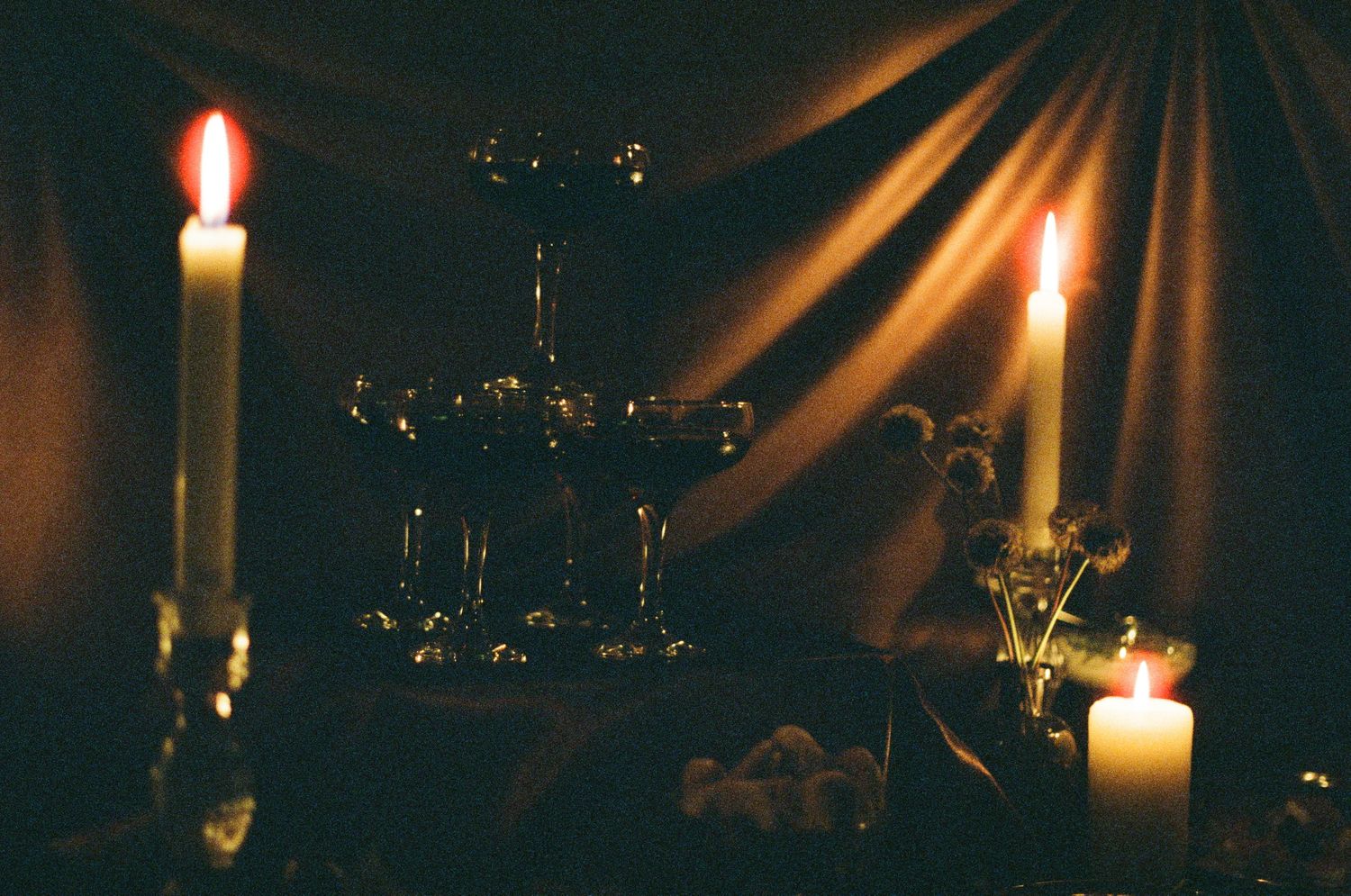 Candles create dramatic lighting effects with beams of light radiating through darkness.