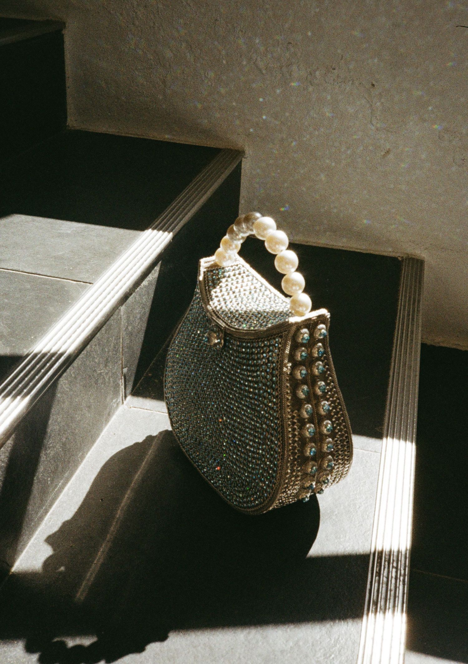 Vintage beaded evening purse photographed in dramatic lighting and shadows.