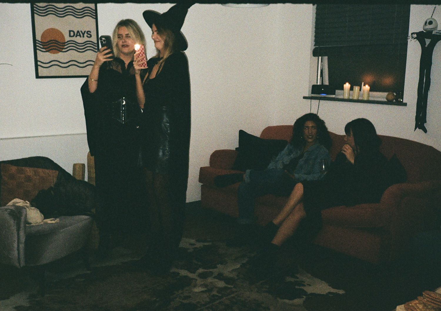 A dark panoramic view of a Halloween party setup with figures in costumes.