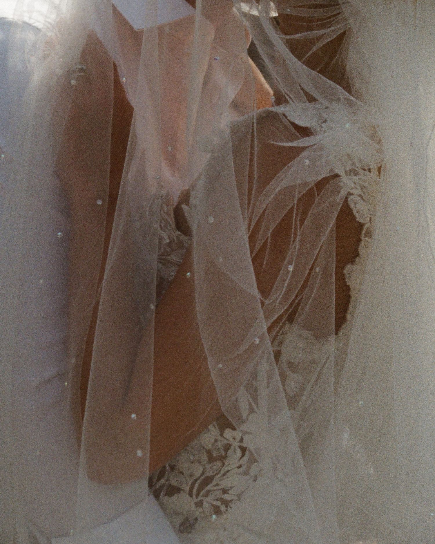 Close-up details of delicate white lace wedding dress fabric.