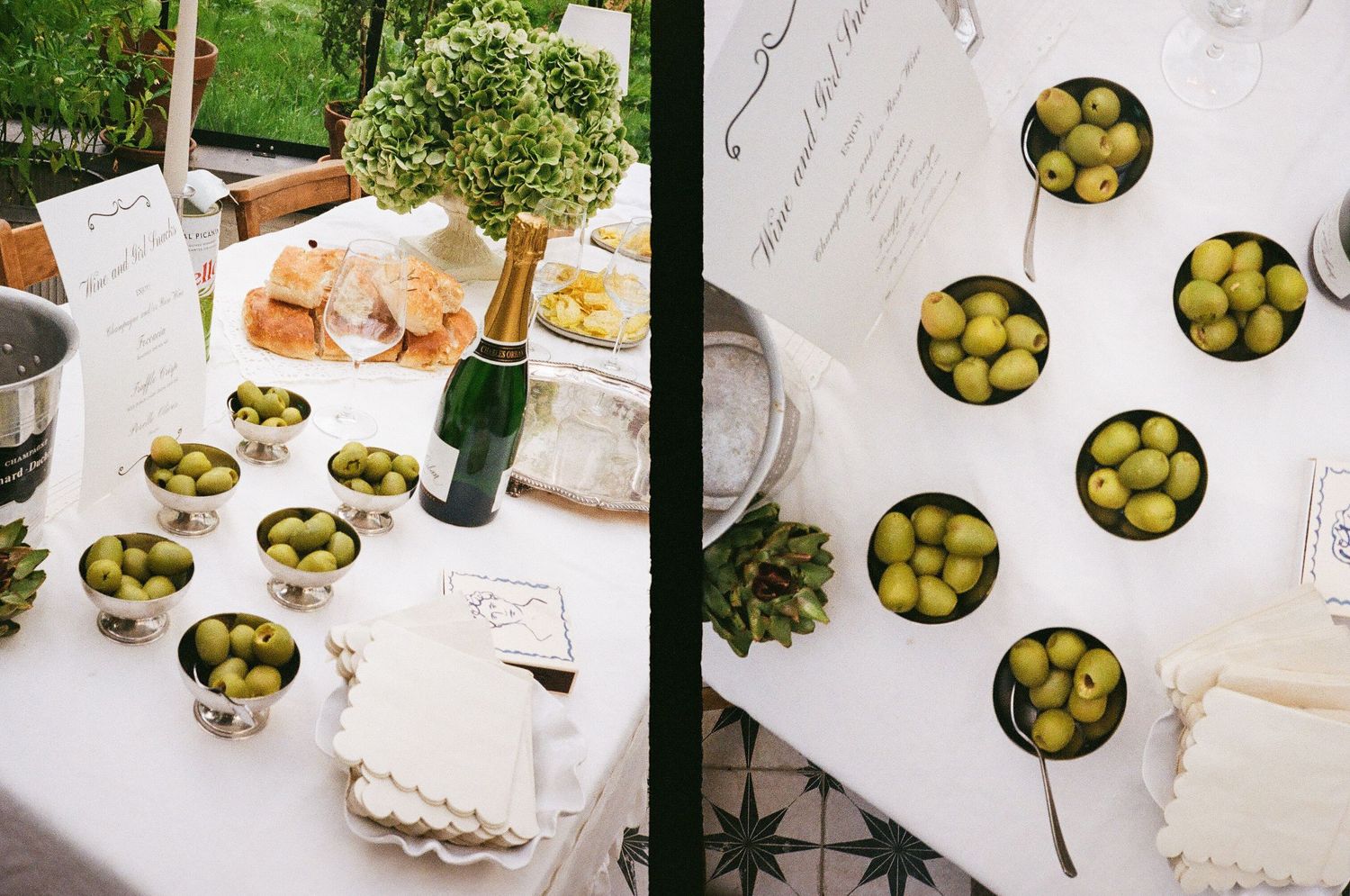 Overhead view of party table settings with olives and decorative greenery.