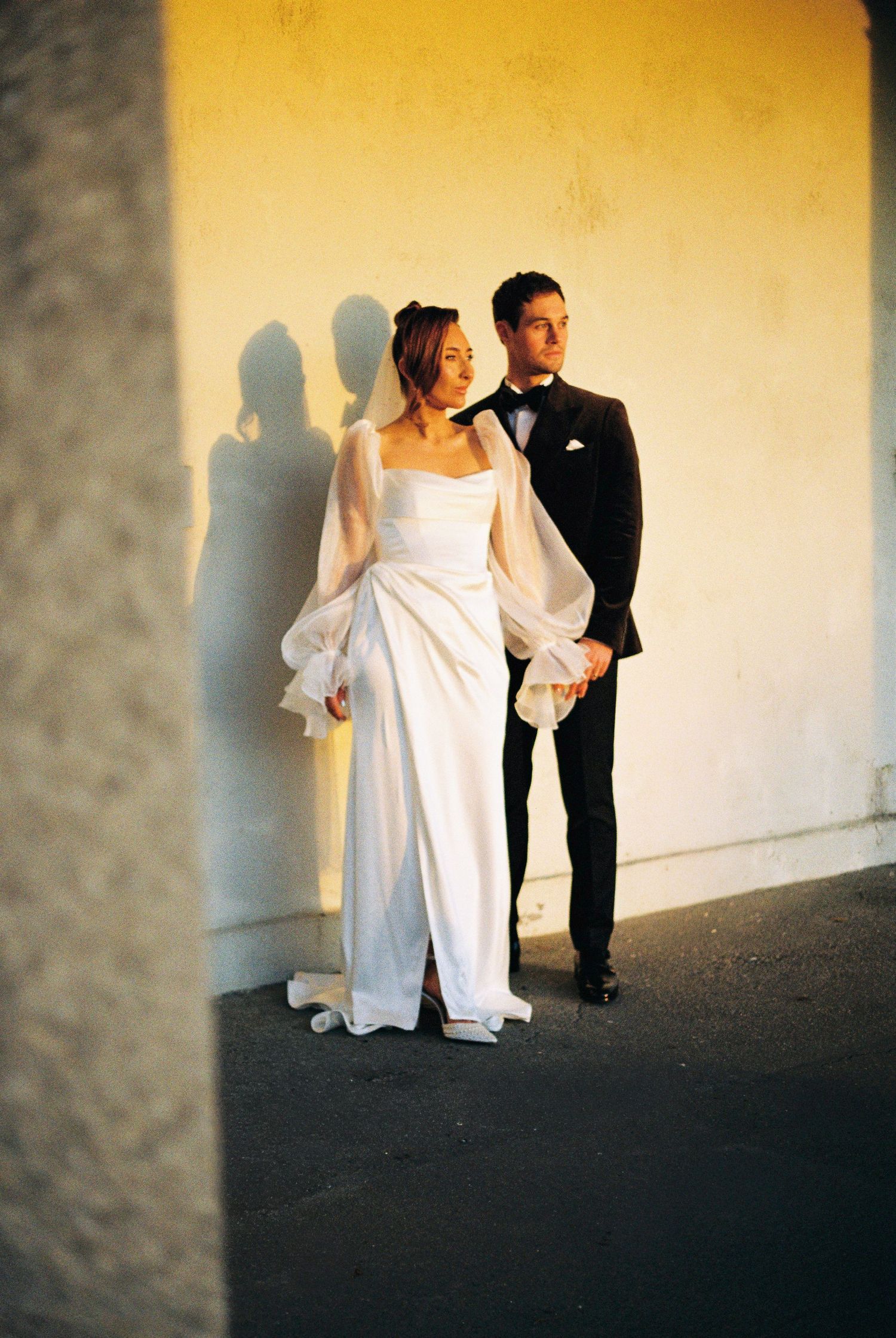 A sequence of wedding photos showing a couple in formal attire casting dramatic shadows against a light wall.