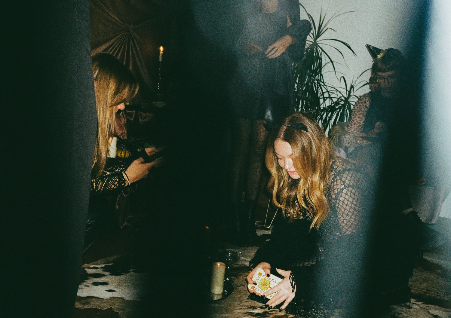 Friends sitting together at a dimly lit table during an evening hangout.