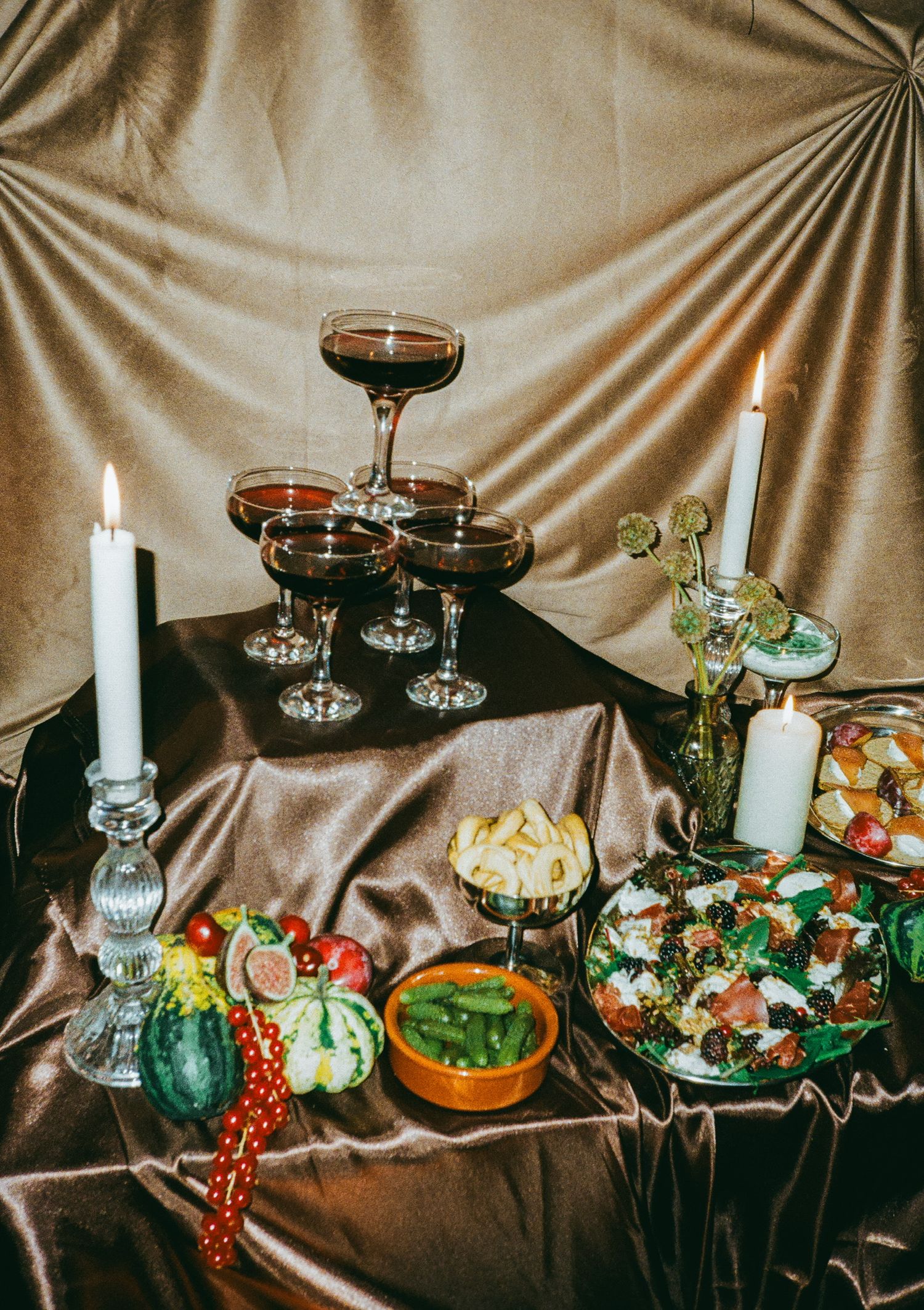 Elegant Halloween party spread with wine glasses, candles and autumn decorations.