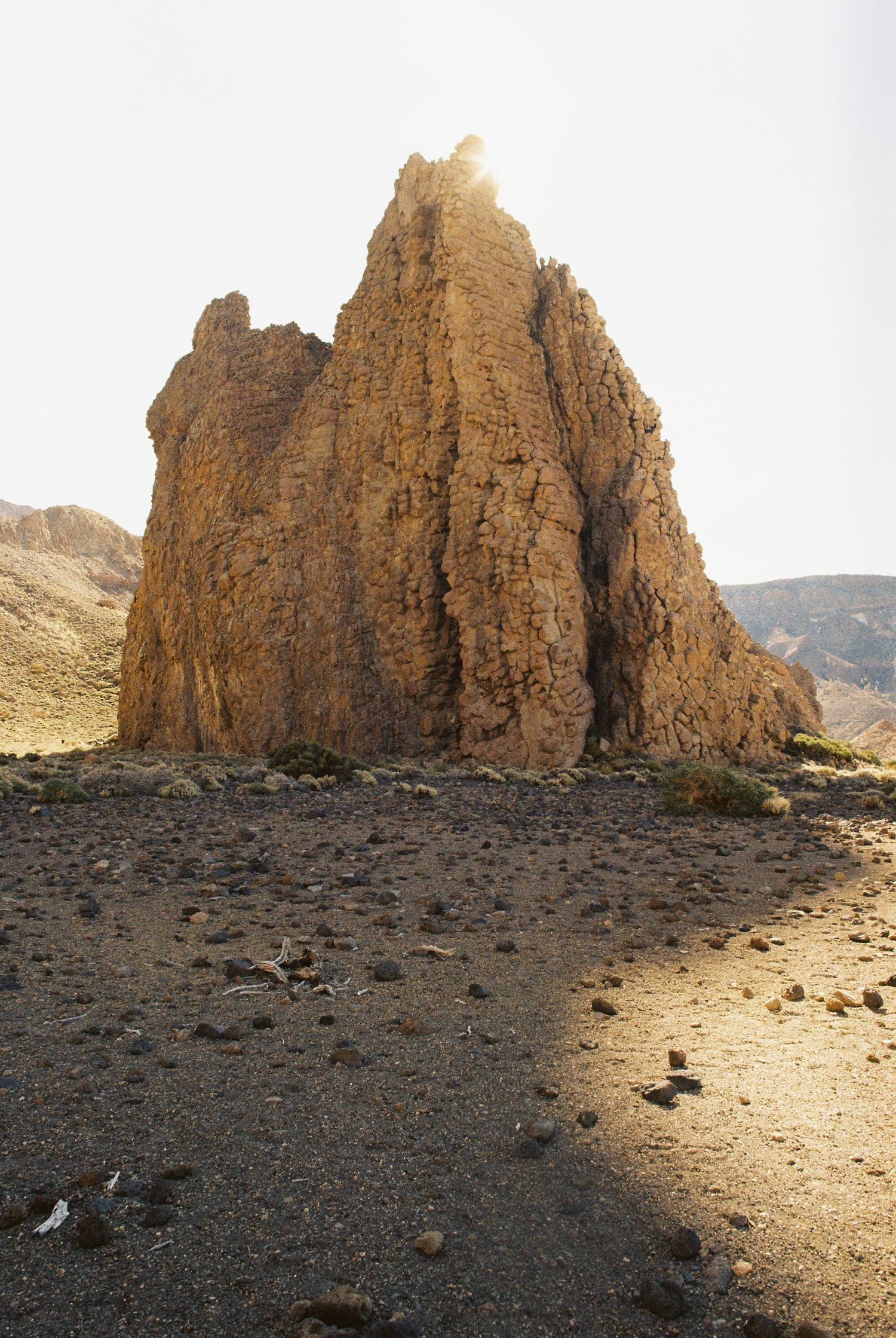 Rocky desert landscape with large jagged rock formations against clear sky.