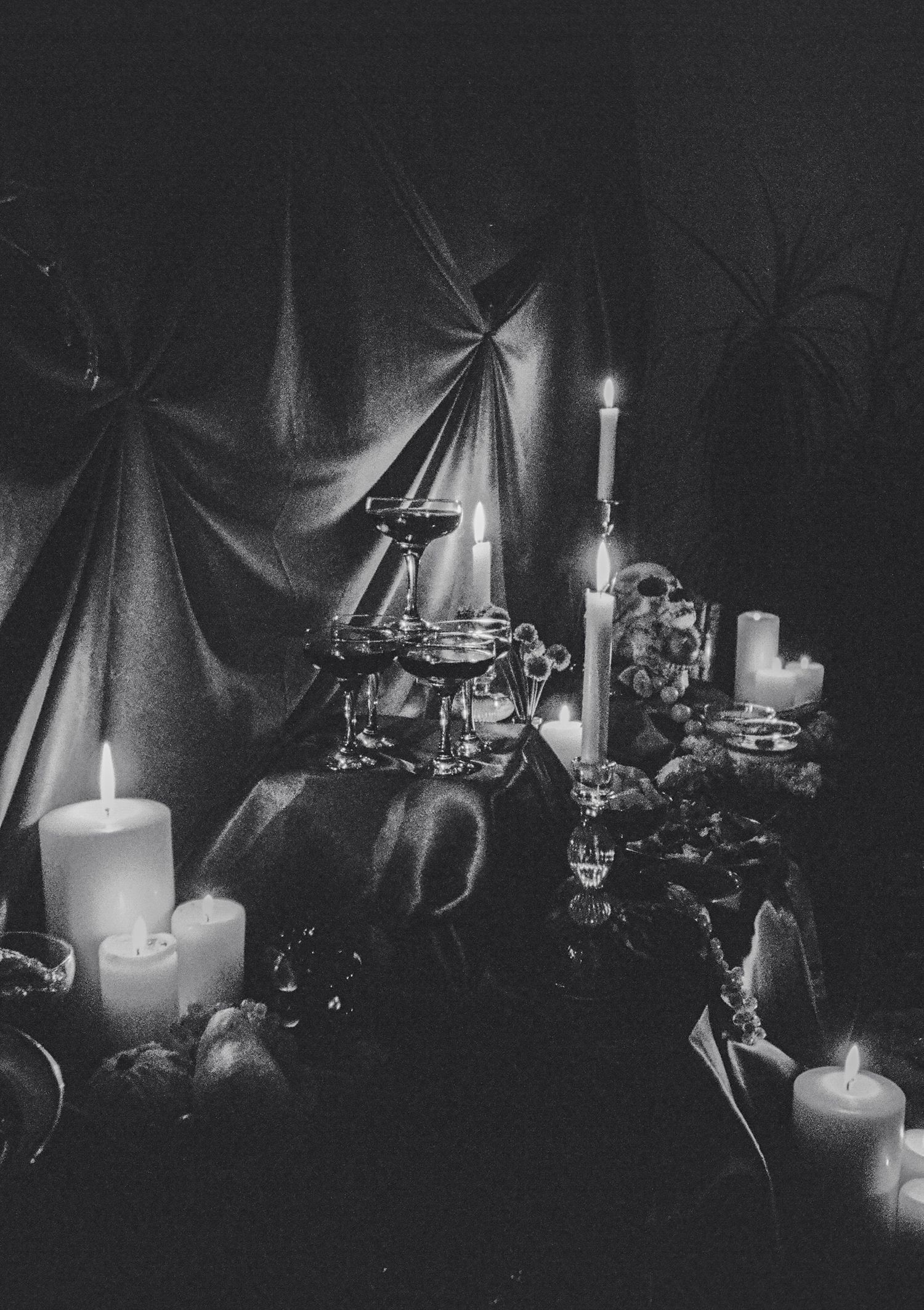 Multiple white candles creating an atmospheric glow against a dark background.