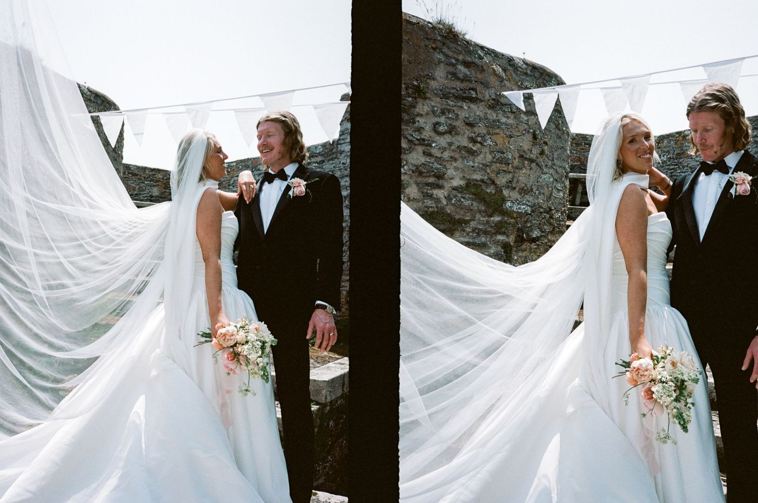 A flowing white wedding dress billows in the wind against a stone wall backdrop.