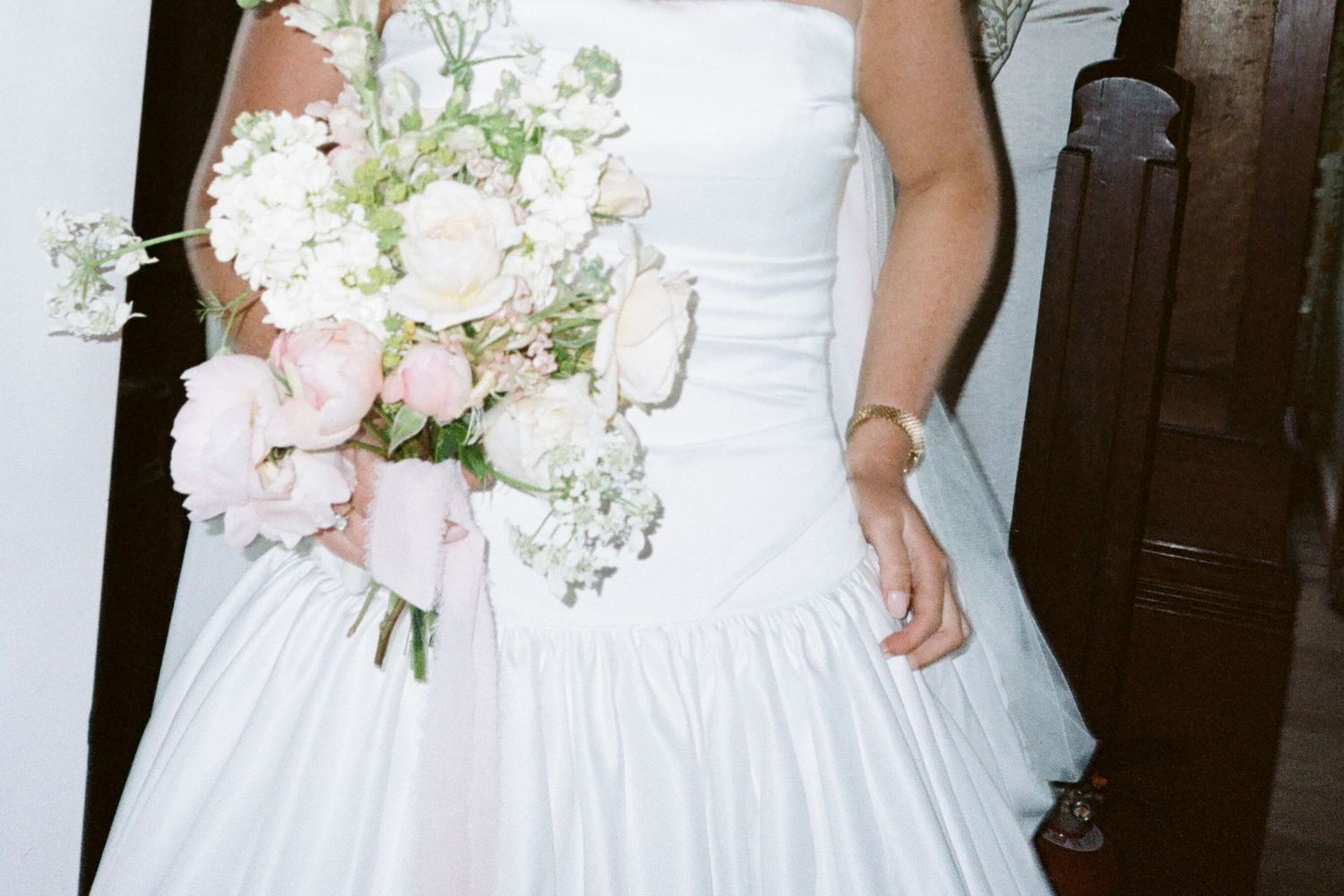 Close-up of white wedding dress with delicate floral details.