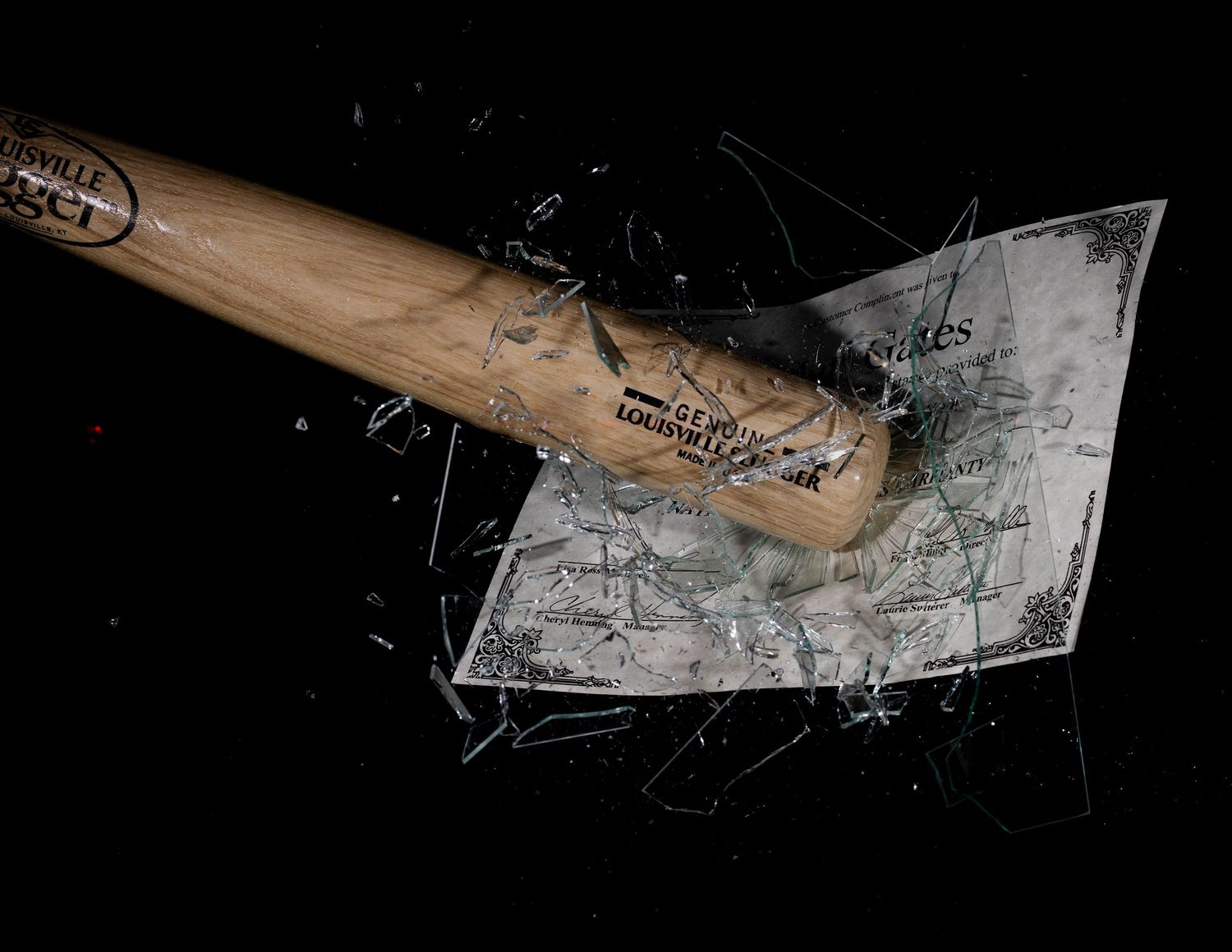 Hands breaking apart electronic components on a dark surface.