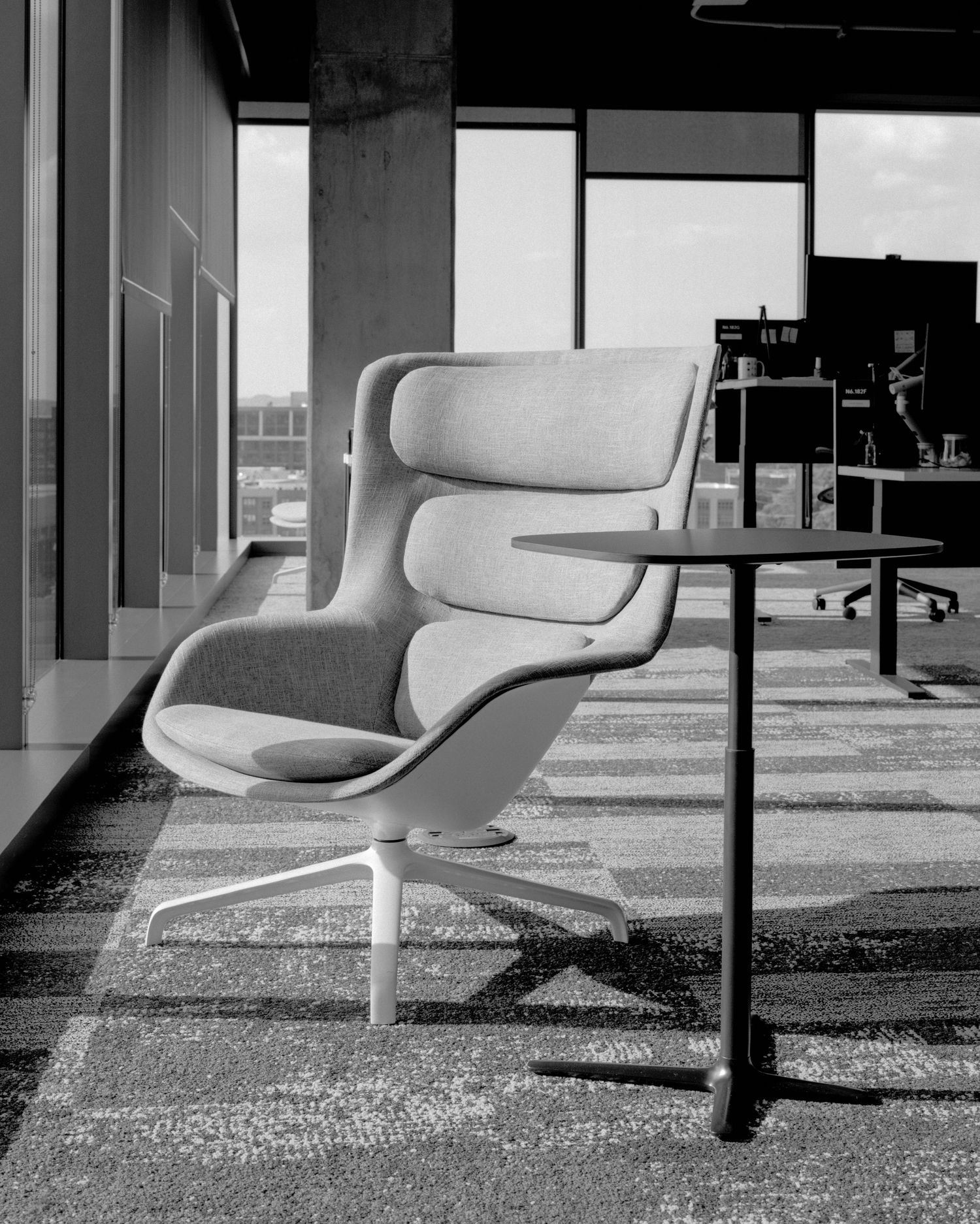 Modern white office chairs arranged in a row on textured carpet in a minimalist workspace.