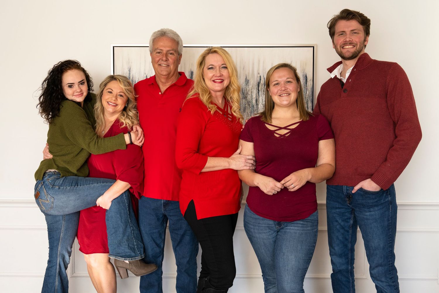 Large family group wearing coordinated outfits posing together for professional photo.