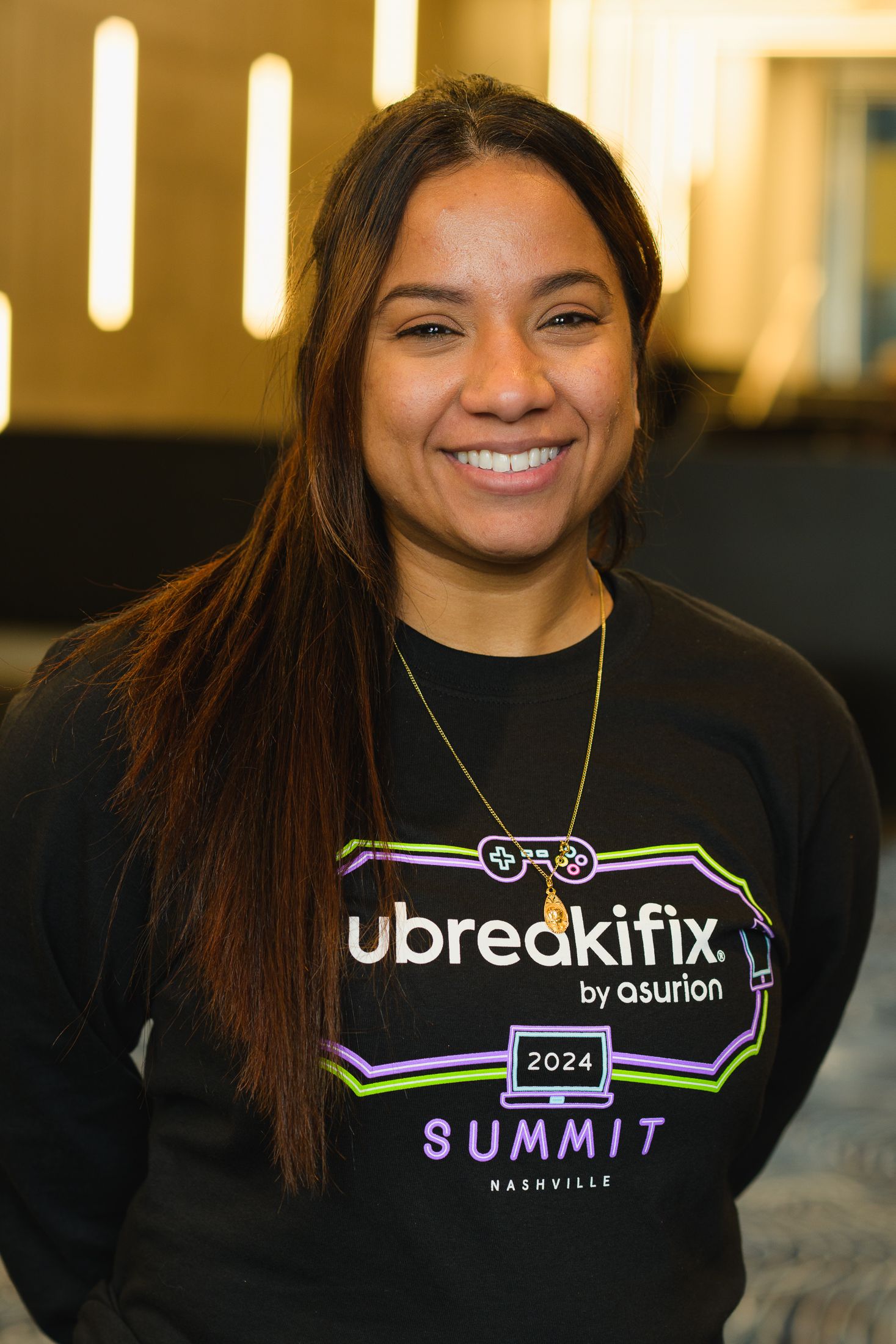 Person wearing a black summit-branded sweater smiling at the camera.