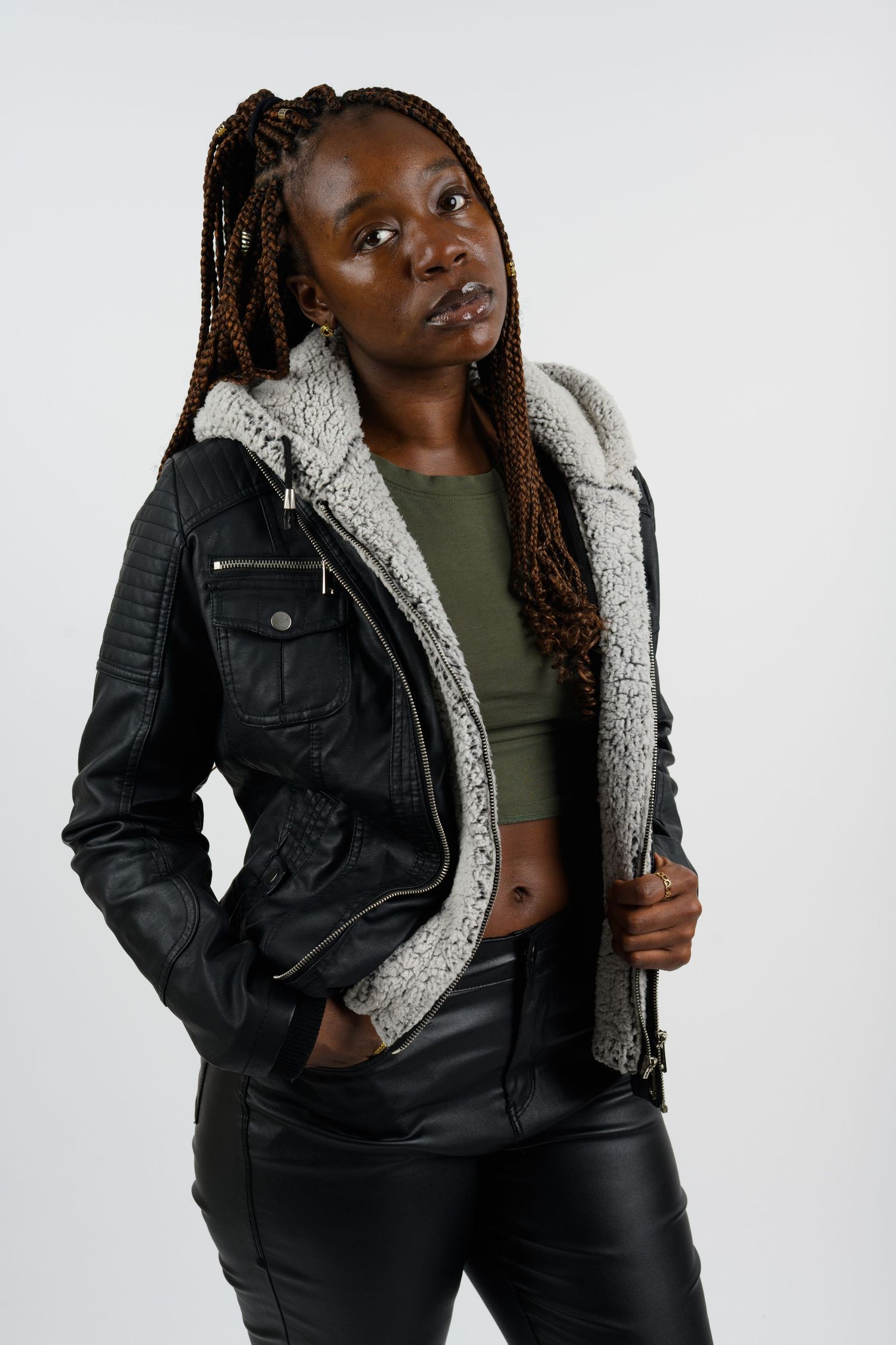 Model wearing black leather jacket with sherpa lining poses against white background.