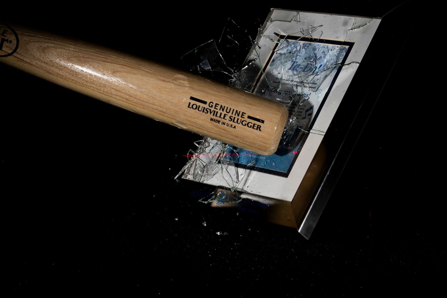 Dark wooden surface with partially visible objects and papers in low lighting conditions.