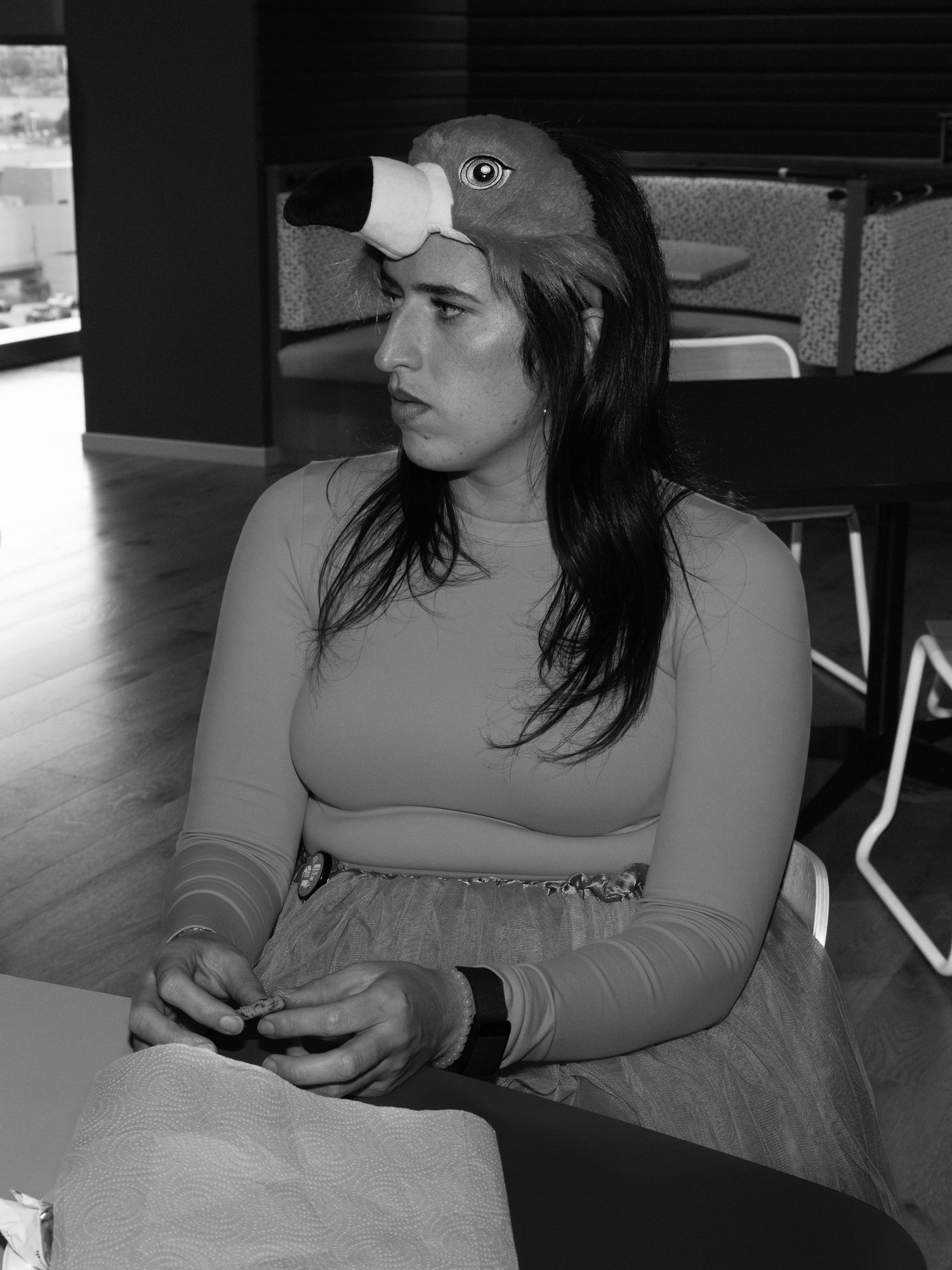 Person in casual attire resting on a couch while checking their phone.