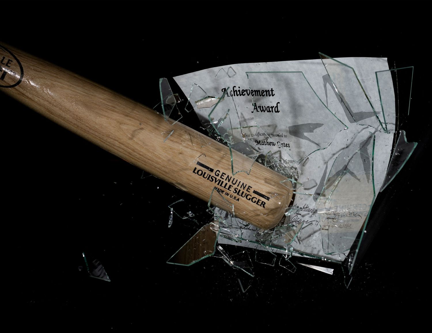A collection of broken glass shards and fragments scattered against a dark background.