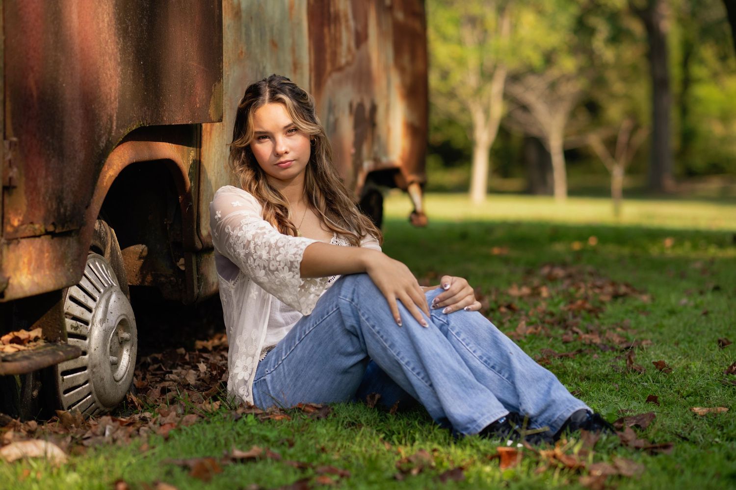 Person relaxing on grass during an outdoor portrait session.