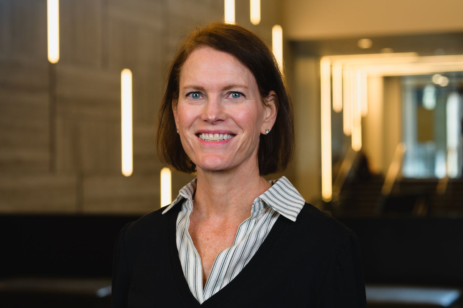 Business portrait of person in professional attire against modern office interior.