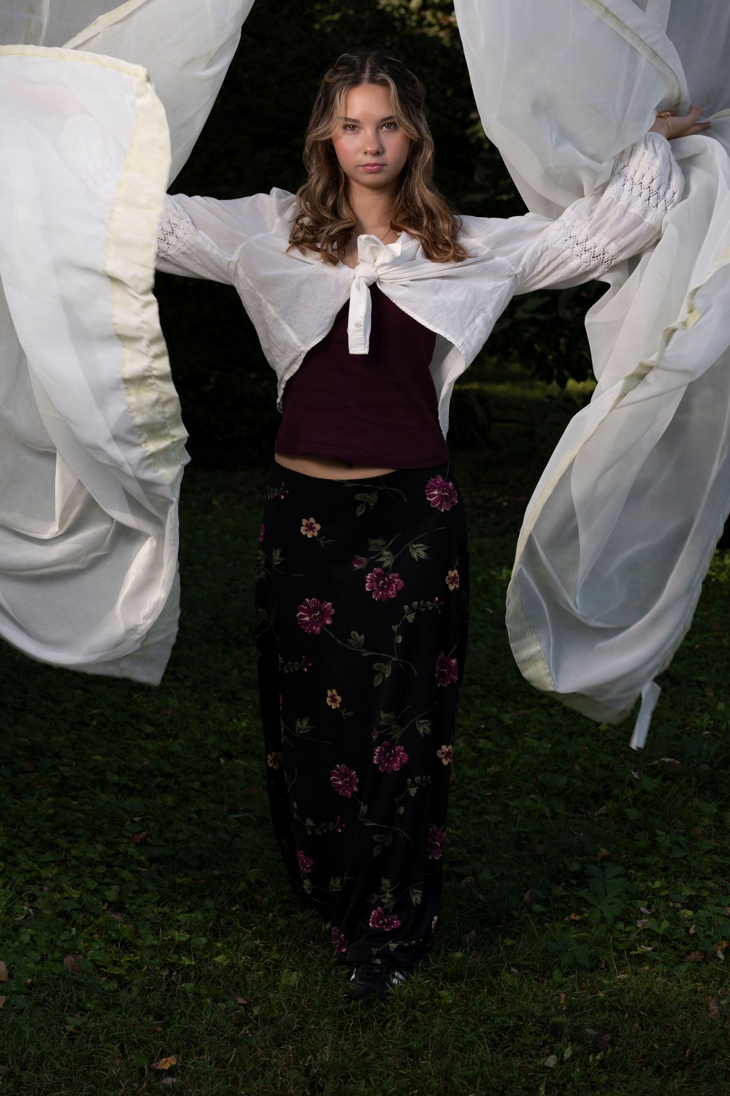 Figure in dark clothing poses with flowing white fabric in outdoor photo sequence.