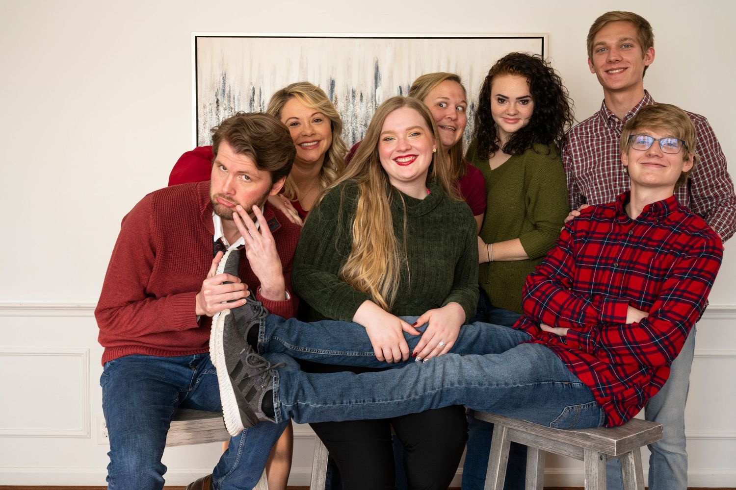 Extended family members arranged in casual poses wearing coordinated outfits for group photo.