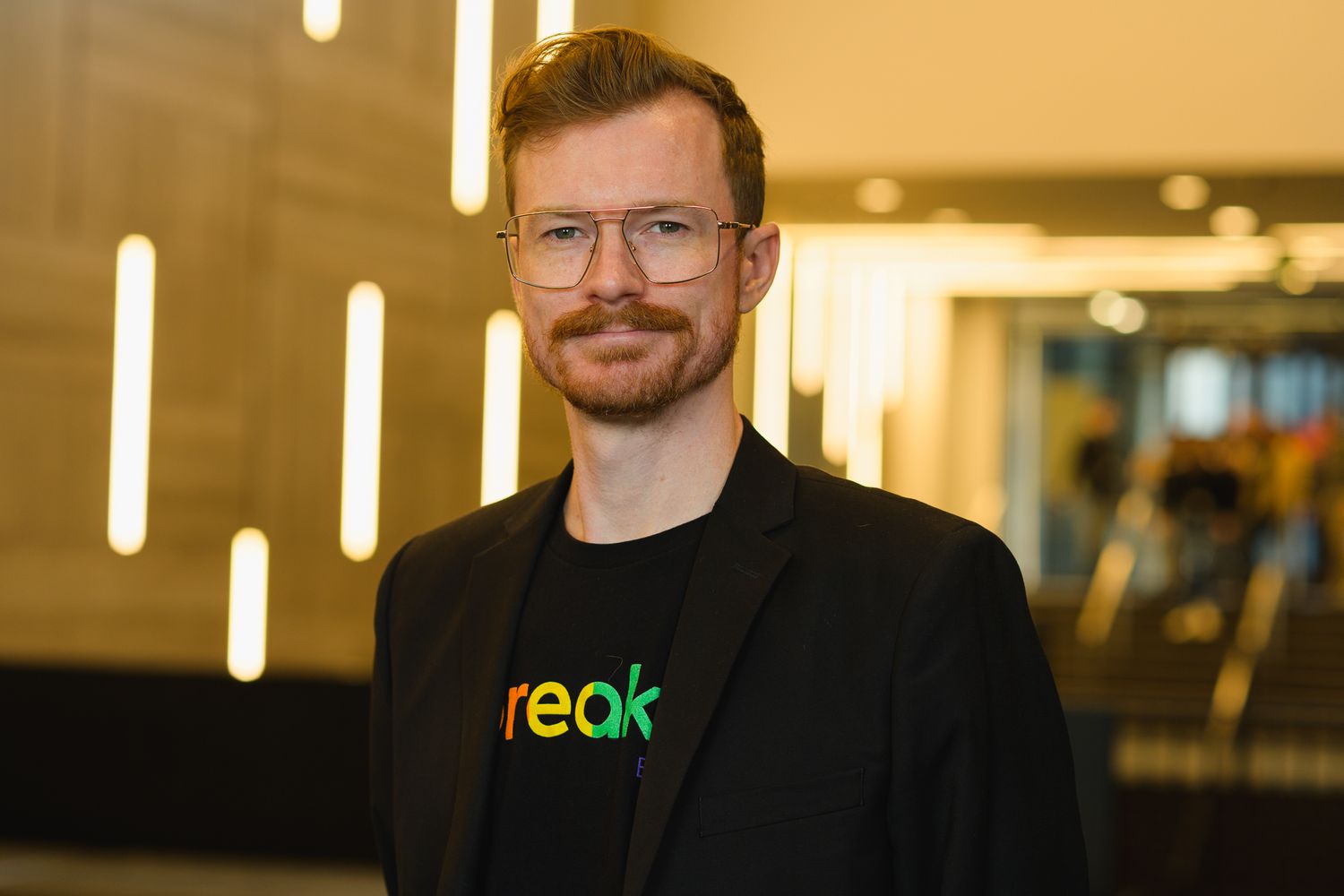 Professional portrait of people in business attire at a corporate event.