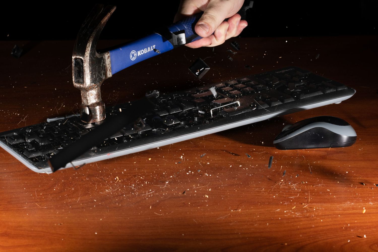 Someone using tools to disassemble electronic equipment on a wooden surface.
