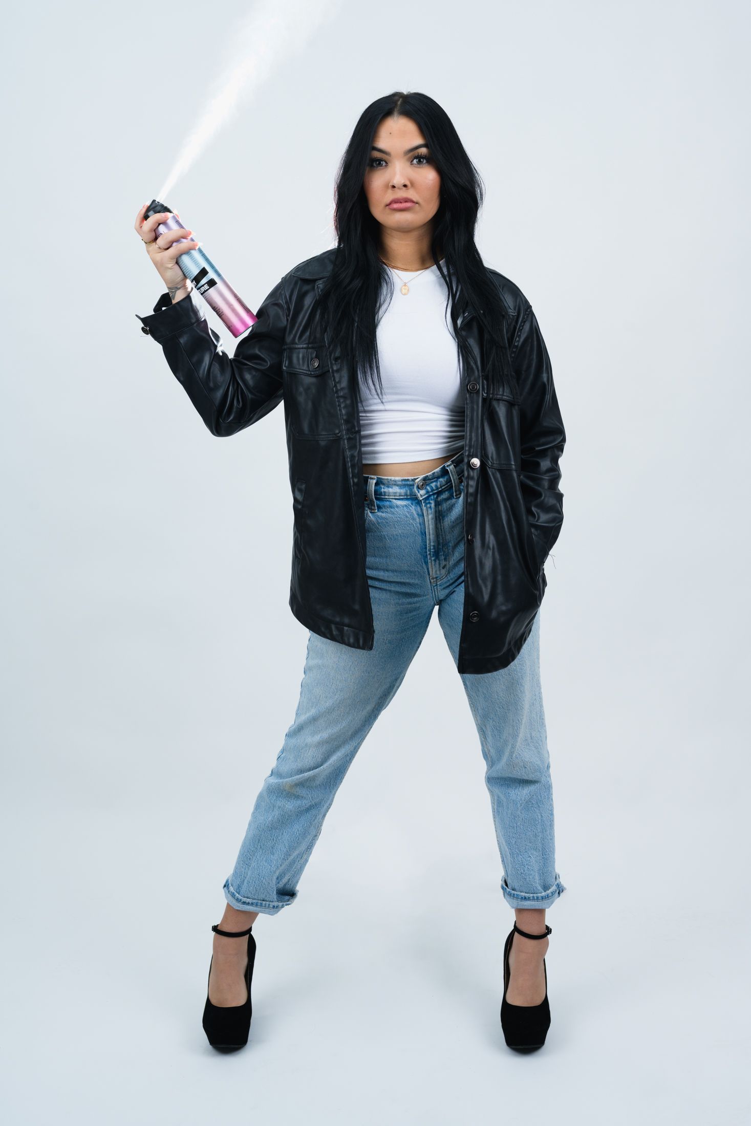 Fashion model wearing black leather jacket and jeans strikes dynamic poses against white backdrop.