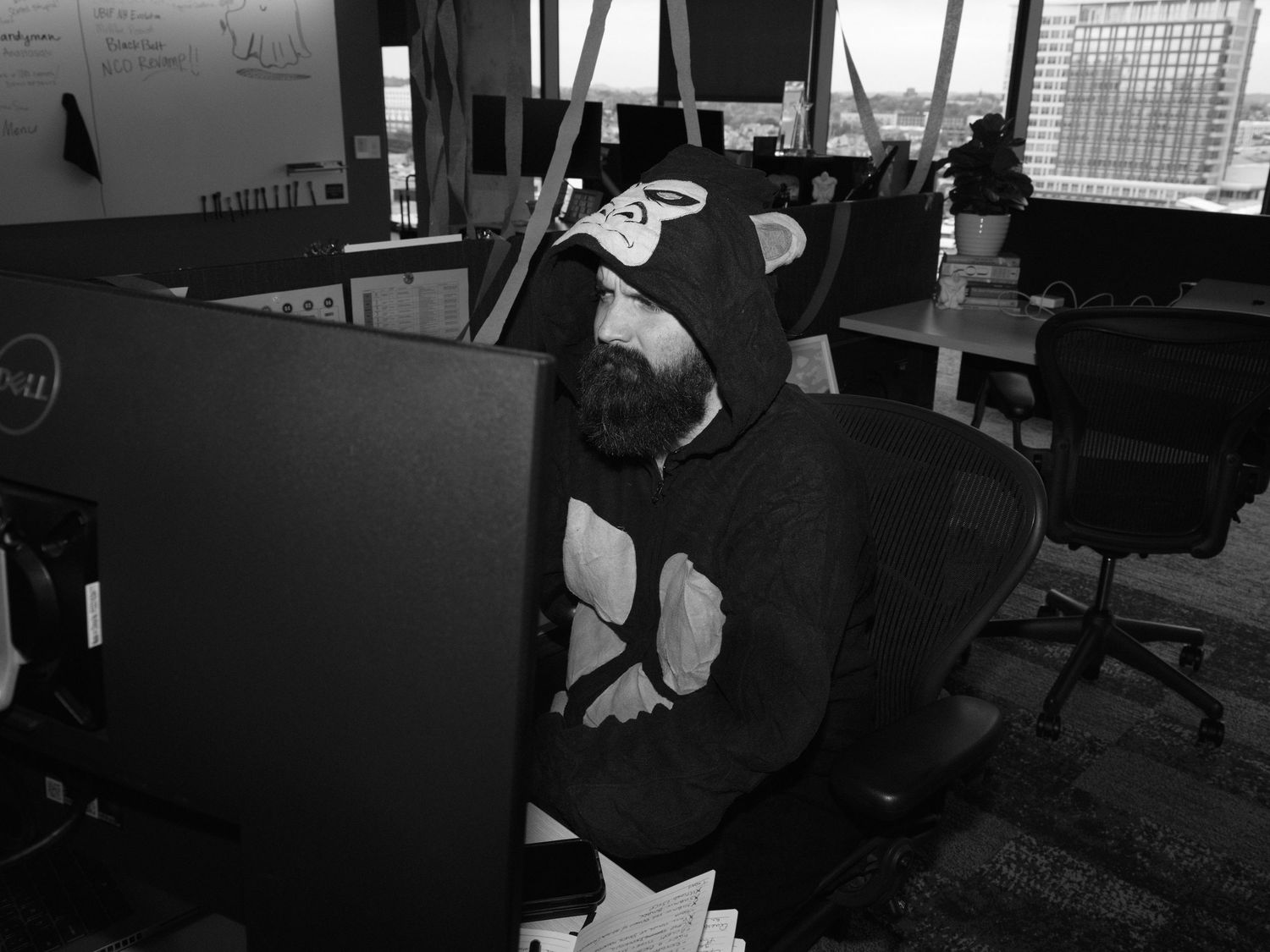 Dark office interior with multiple computer workstations and desk setups.