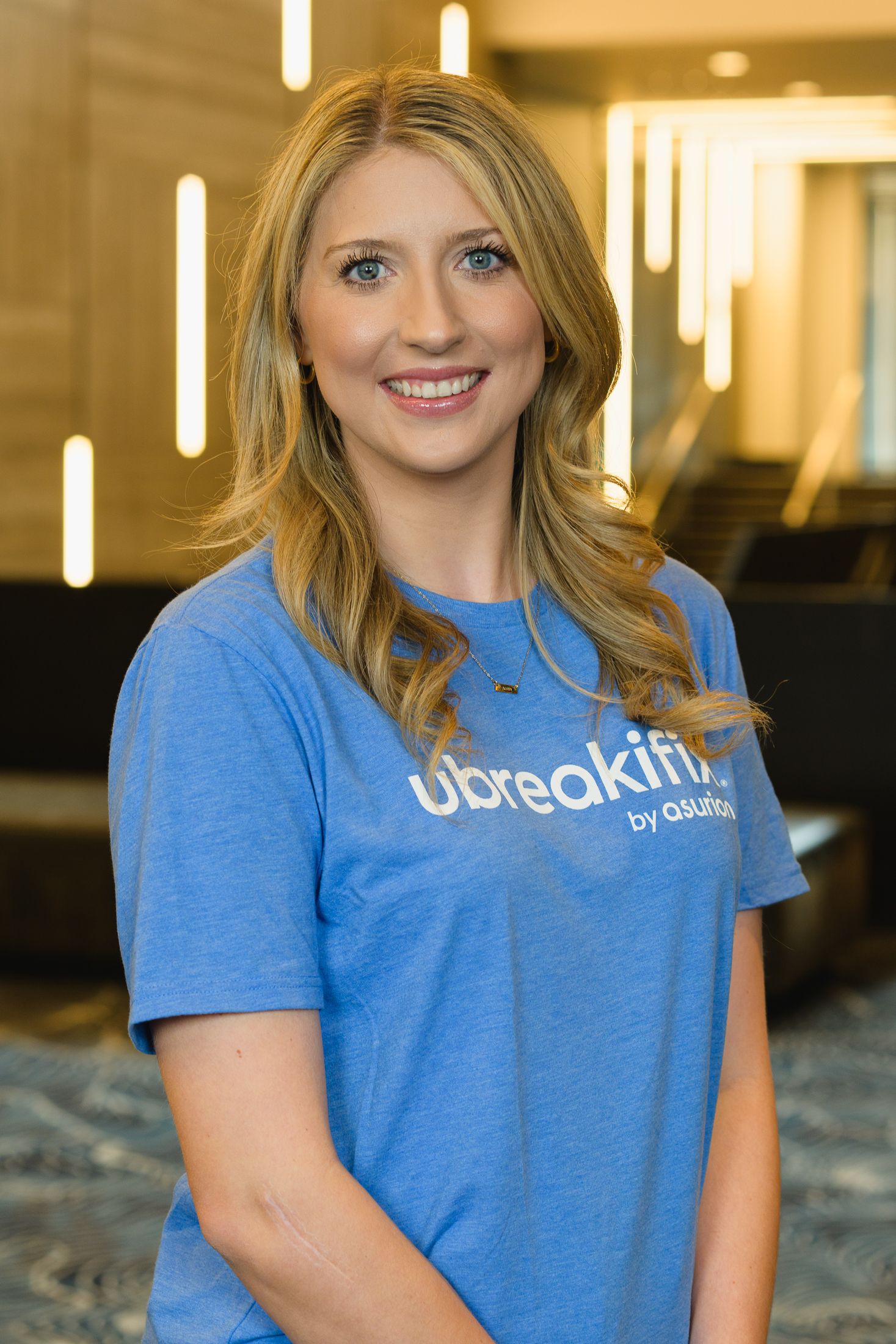 Person wearing a blue Ubreakifix branded t-shirt smiling at the camera.