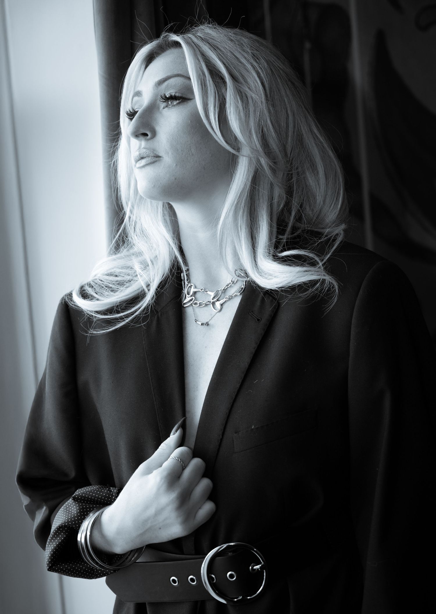 Black and white artistic portrait series showing dramatic poses in moody lighting with elegant styling.