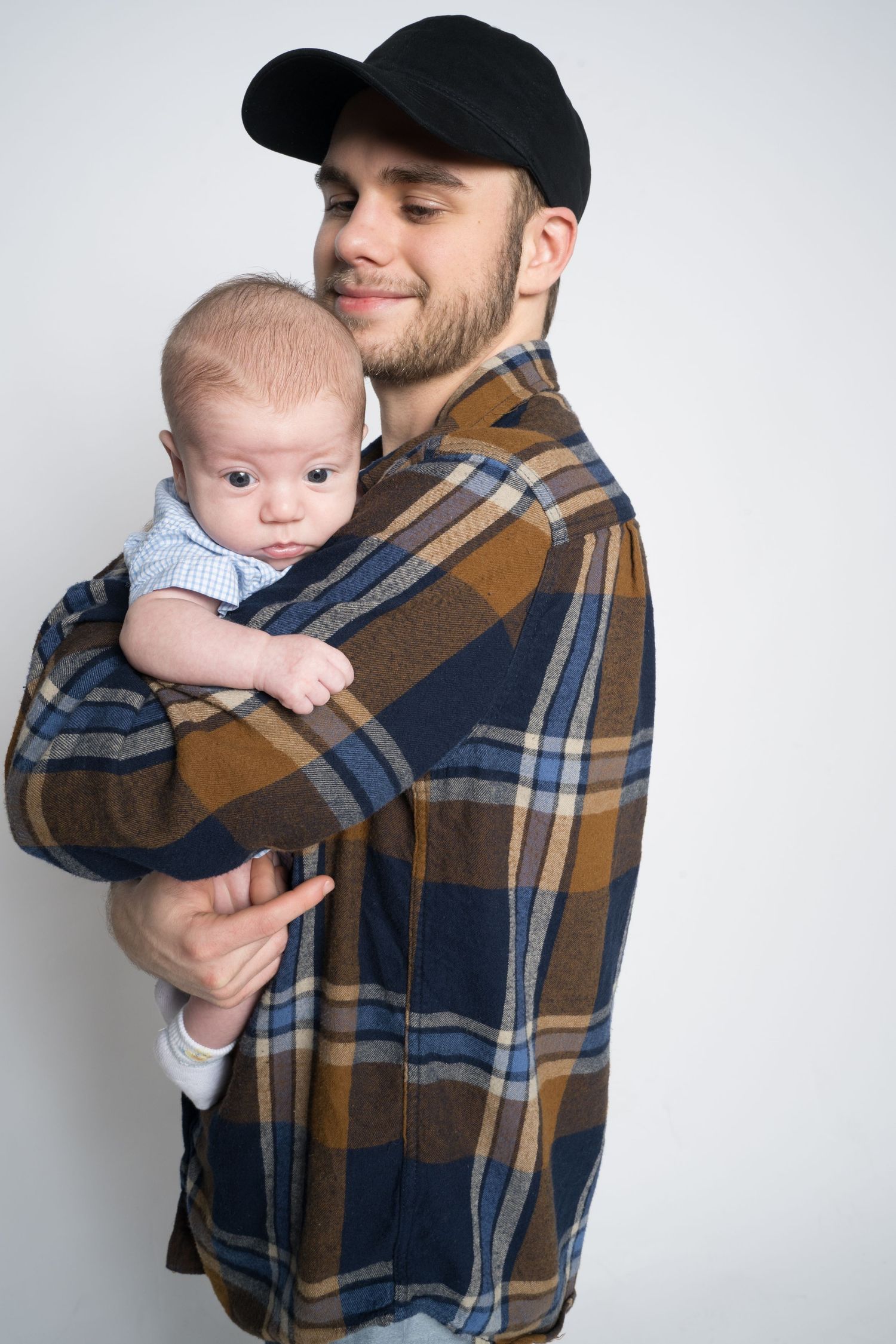 A sequence of photos showing a baby being held in a plaid flannel shirt against a white background.