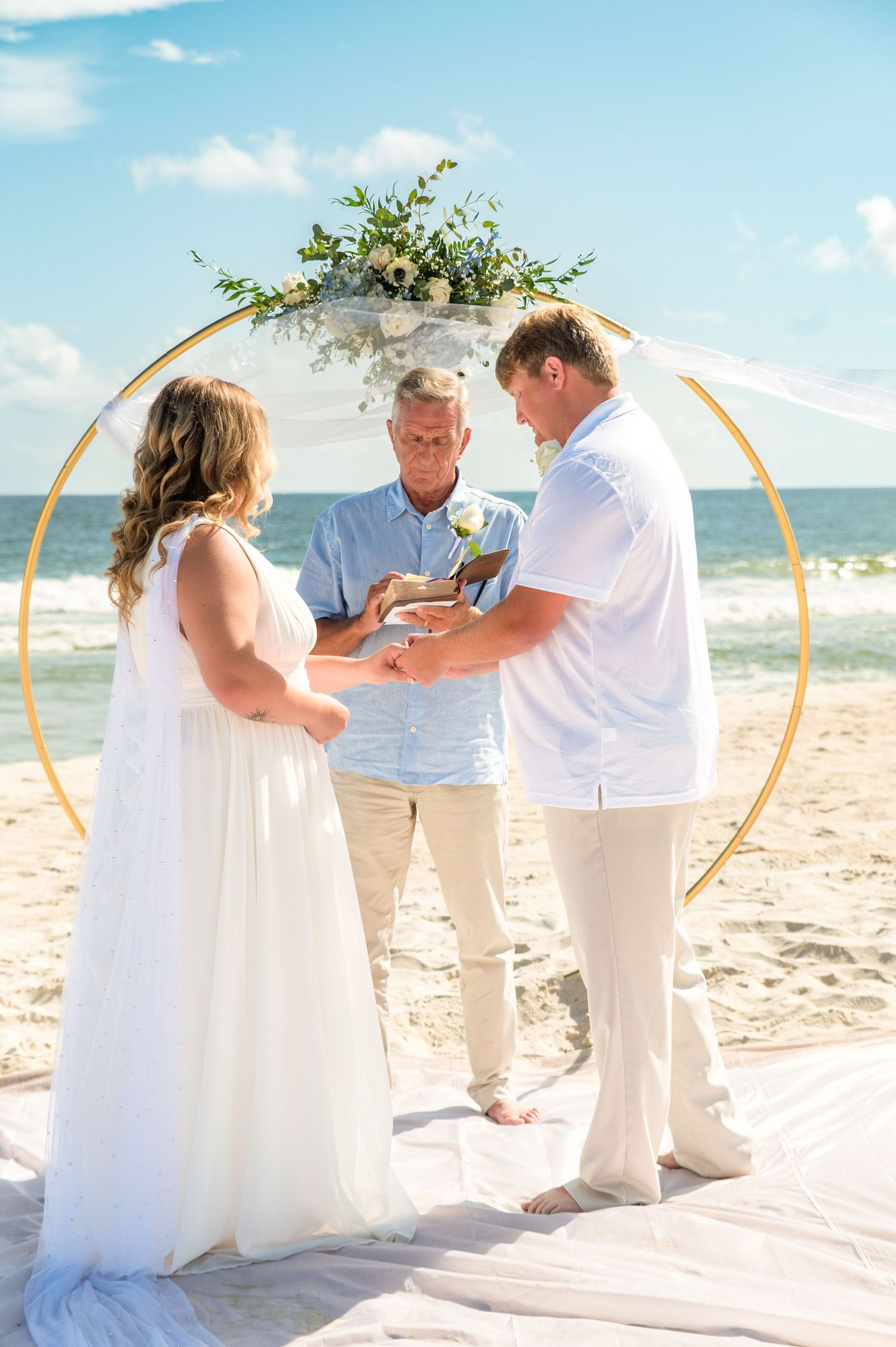 A beach wedding ceremony sequence with white and gold decor against the ocean backdrop.