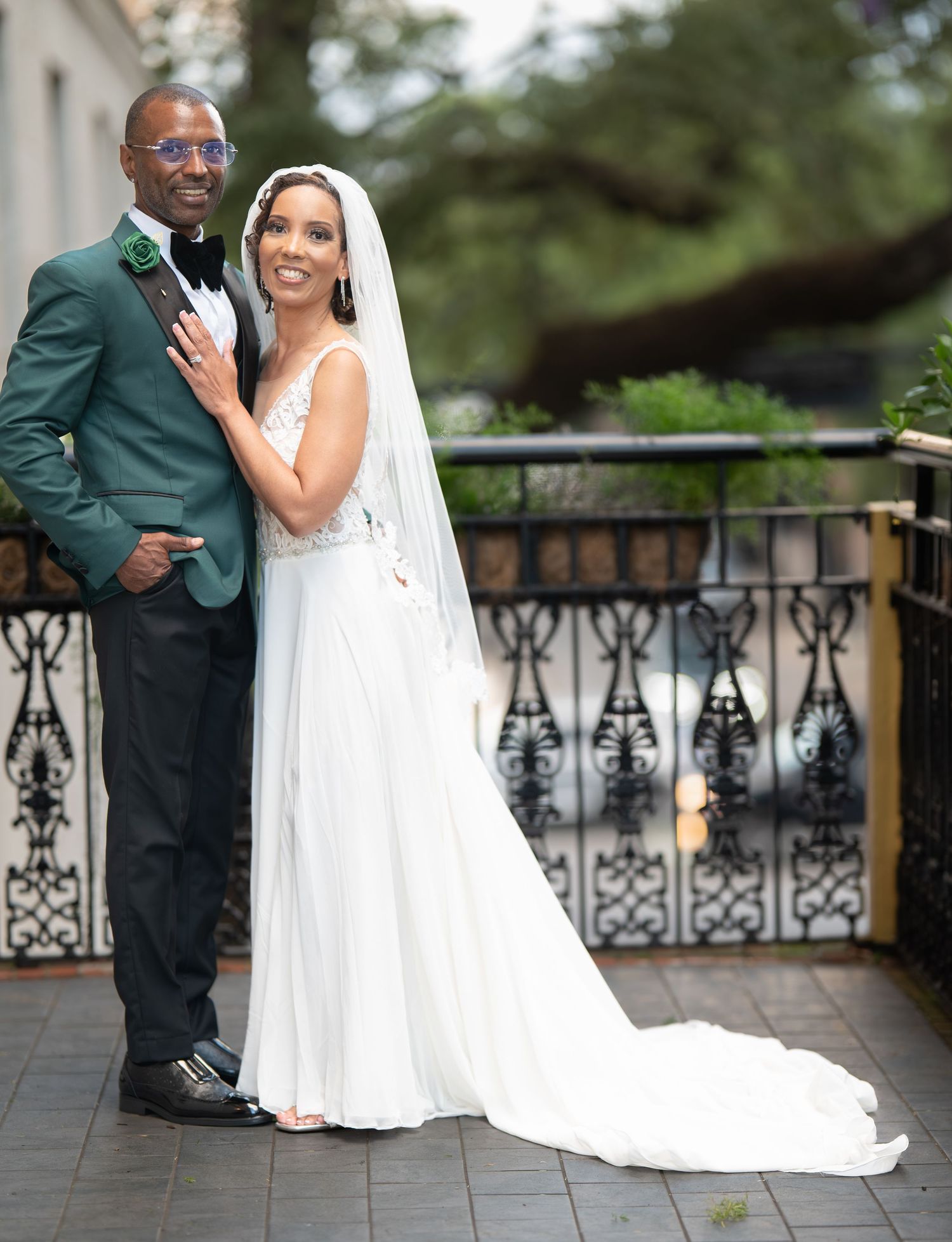 A series of wedding photos showing a couple posing on a terrace with ornate iron railings.