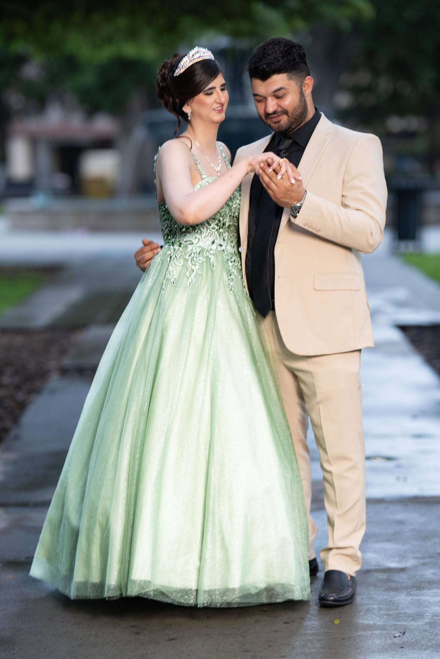 Wedding photos showing a couple in mint green dress and beige suit dancing outdoors.