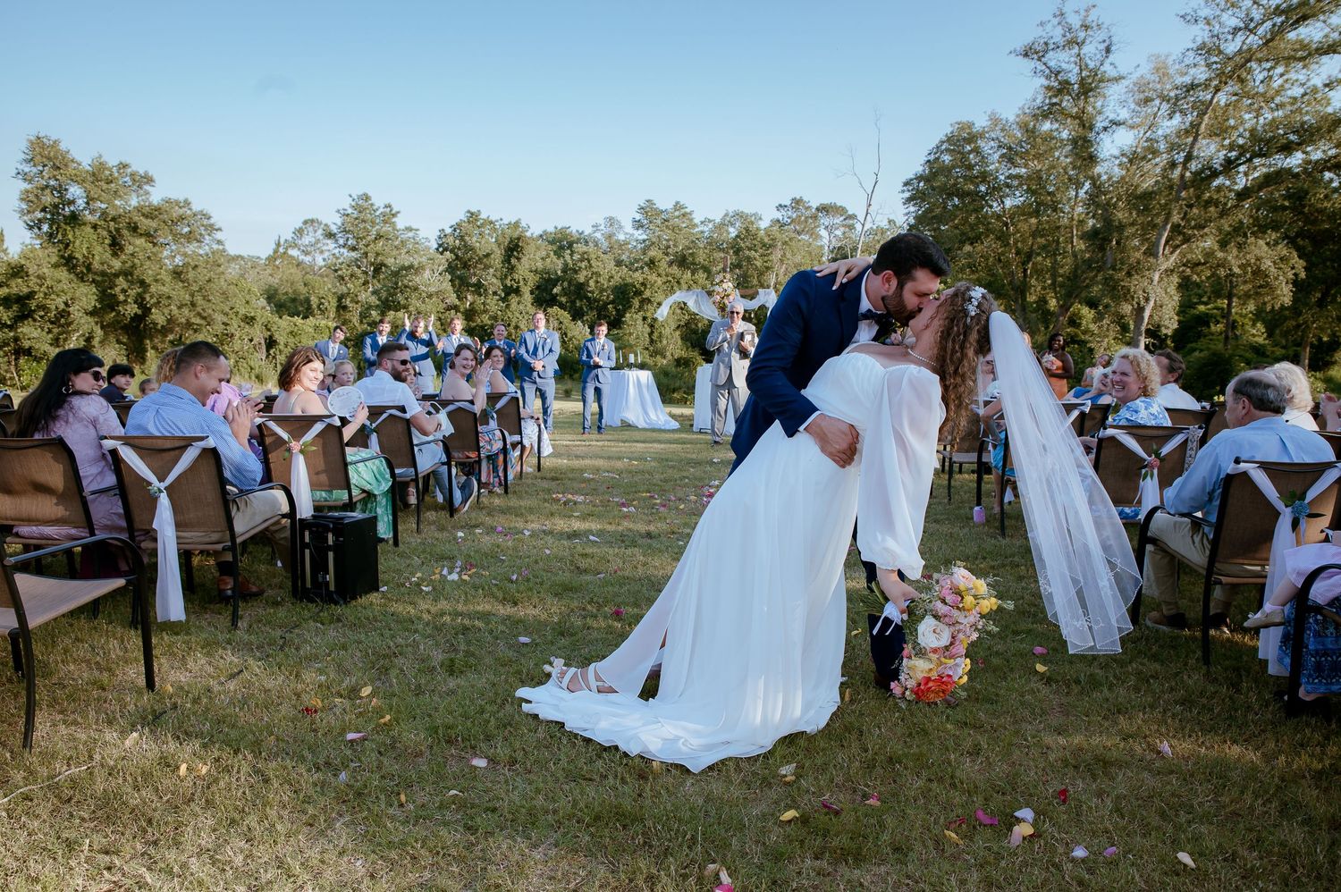 Outdoor wedding reception photos showing guests gathered on a grassy venue.