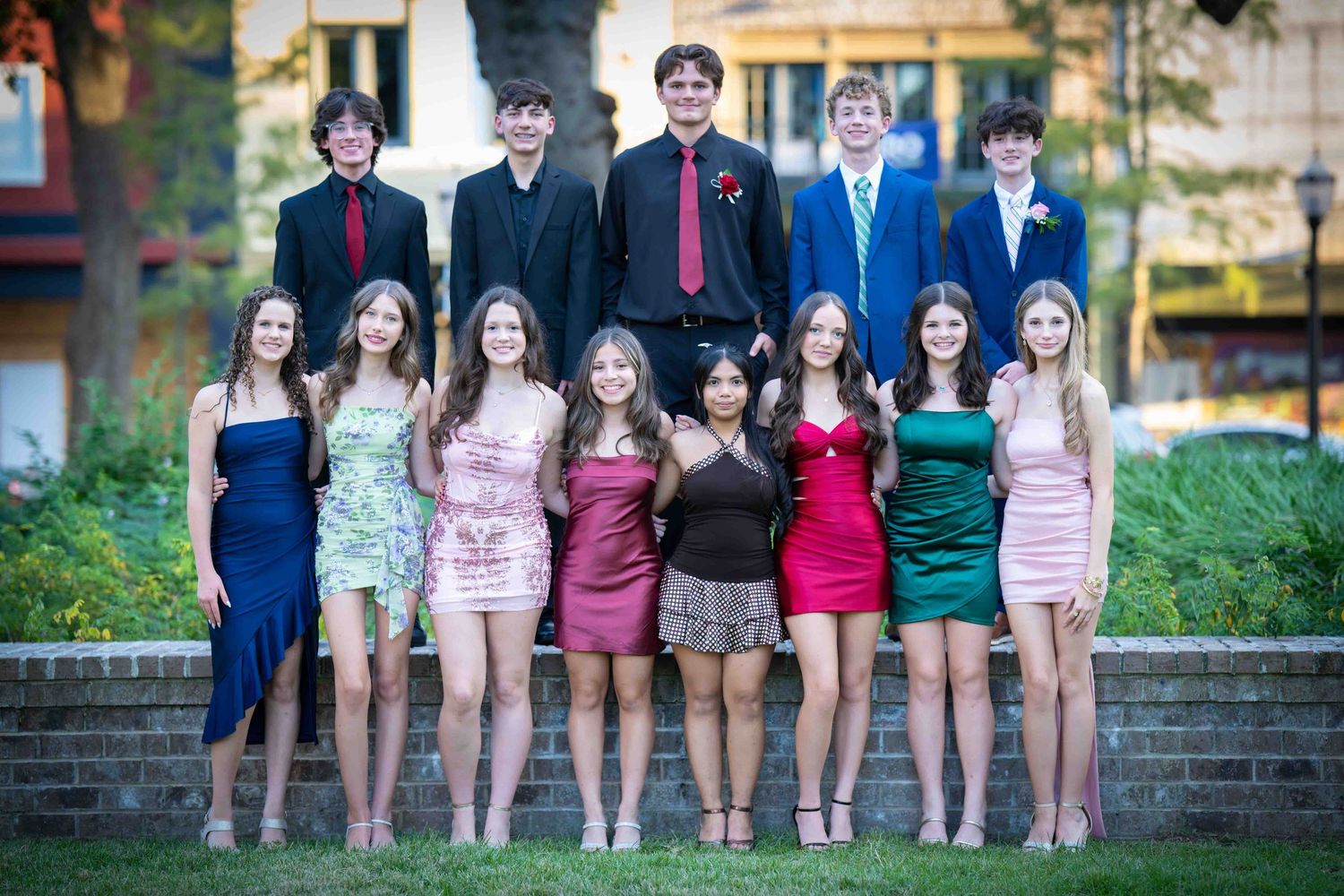 Group of friends in coordinated outfits standing together outdoors for a casual photo session.