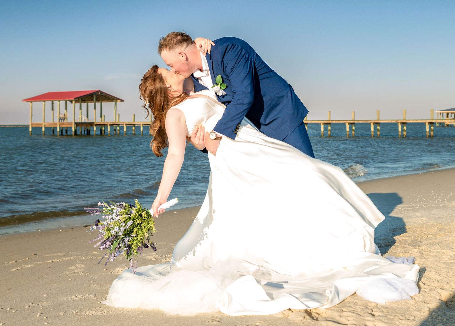 Beach wedding photography sequence showing romantic poses by the ocean pier.