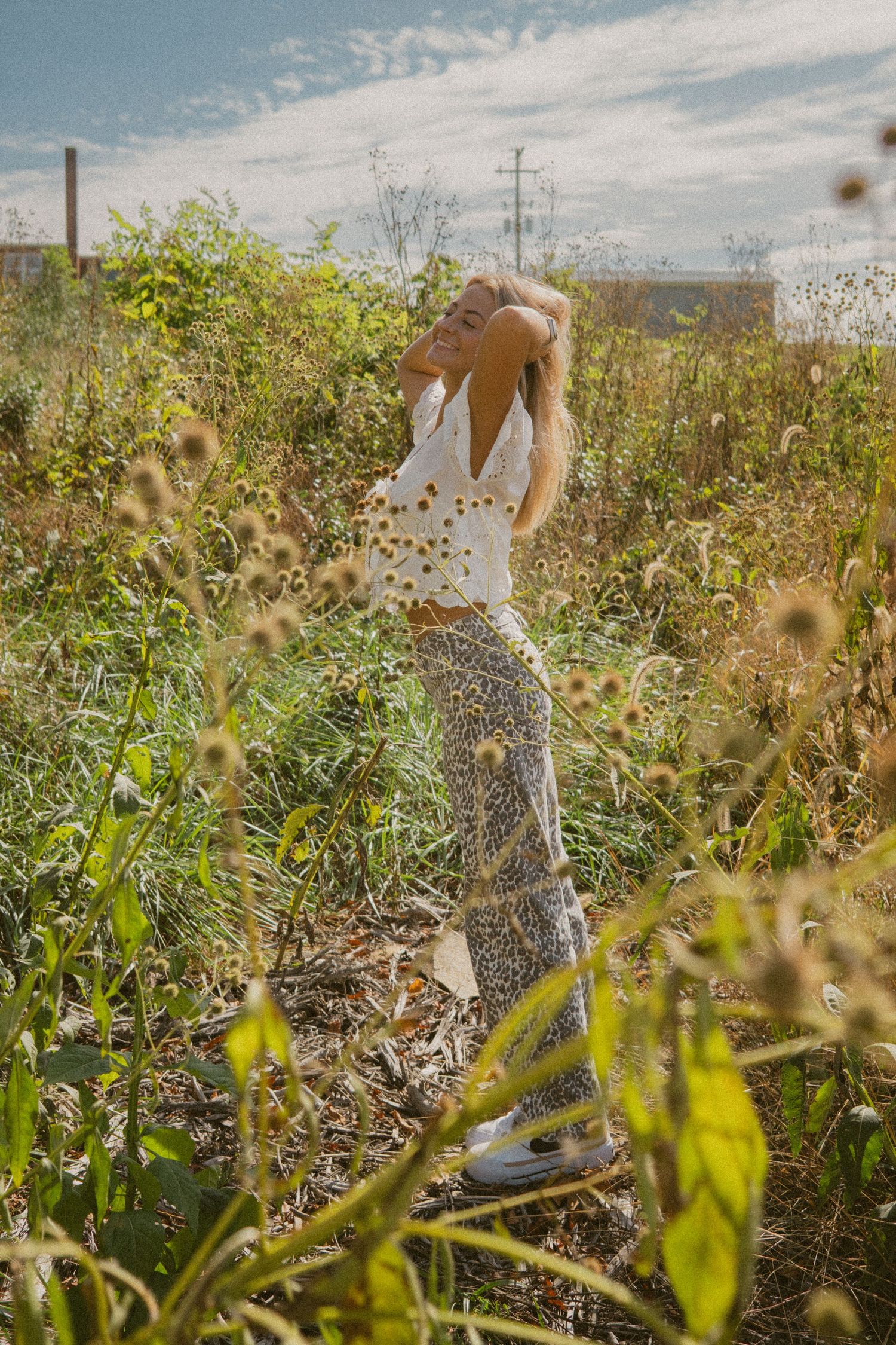 A sequence of photos showing a person dancing and twirling in a sunlit field of wildflowers and tall grass.