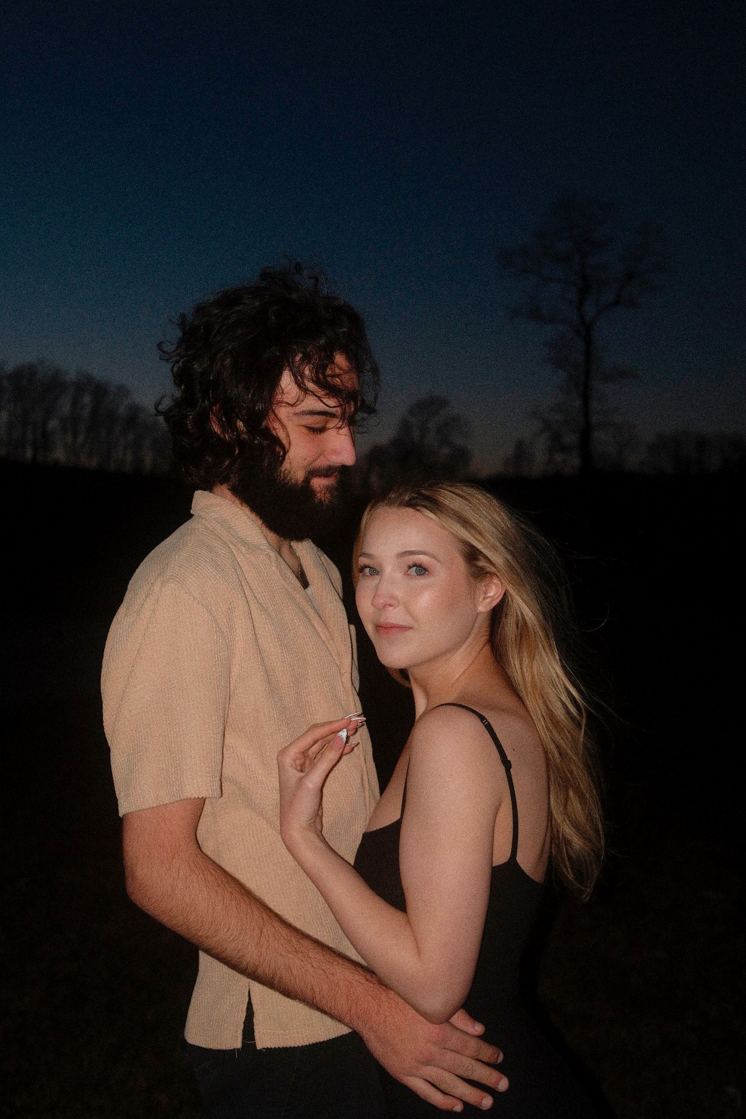 A romantic couple embraces in silhouette against a dusky evening sky in a series of intimate poses.