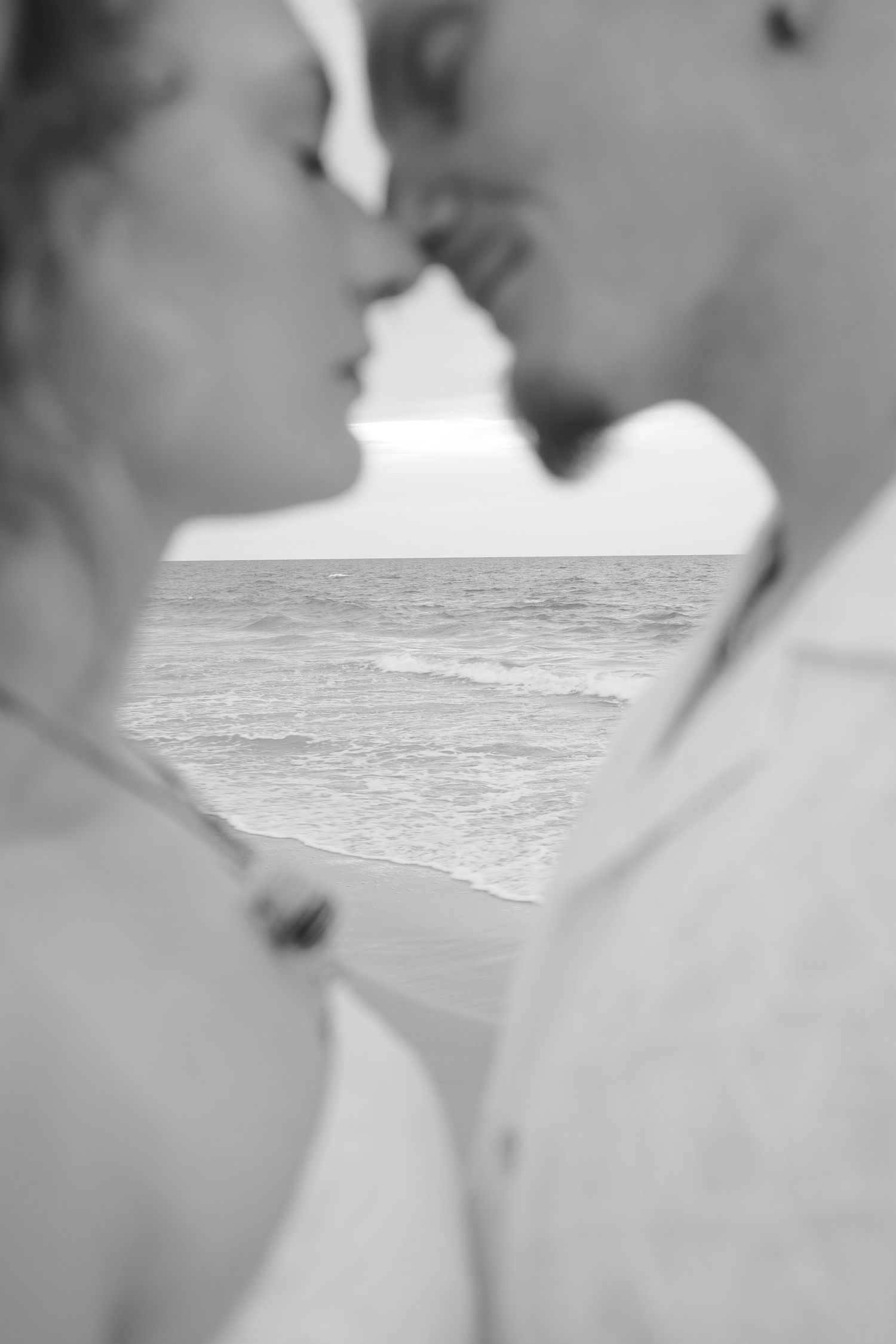 A series of blurry black and white photographs showing abstract shapes and silhouettes against light backgrounds.