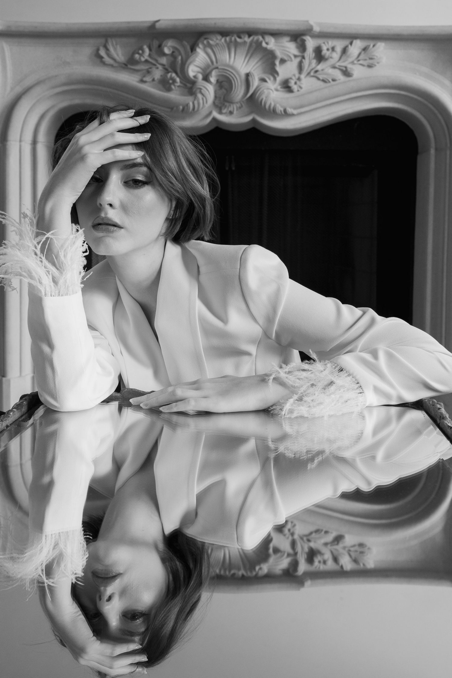 Black and white editorial fashion photo of female model resting on mirrored table at Creative Chateau, Houston, by Sadie Sanders Photography