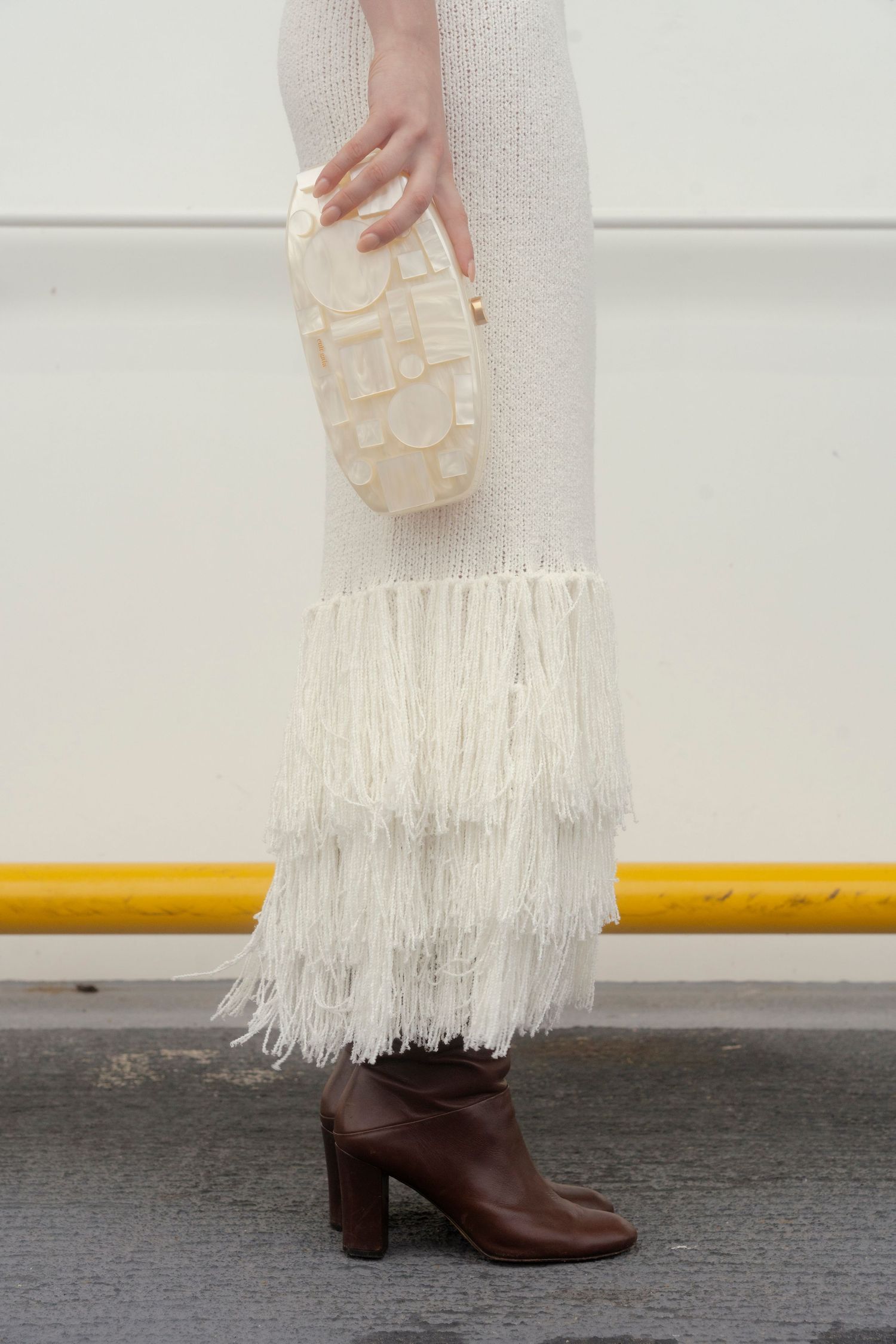 Female model posing on Galveston Ferry with white dress, brown boots, and Cult Gaia bag, styled fashion shoot by Sadie Sanders Photography
