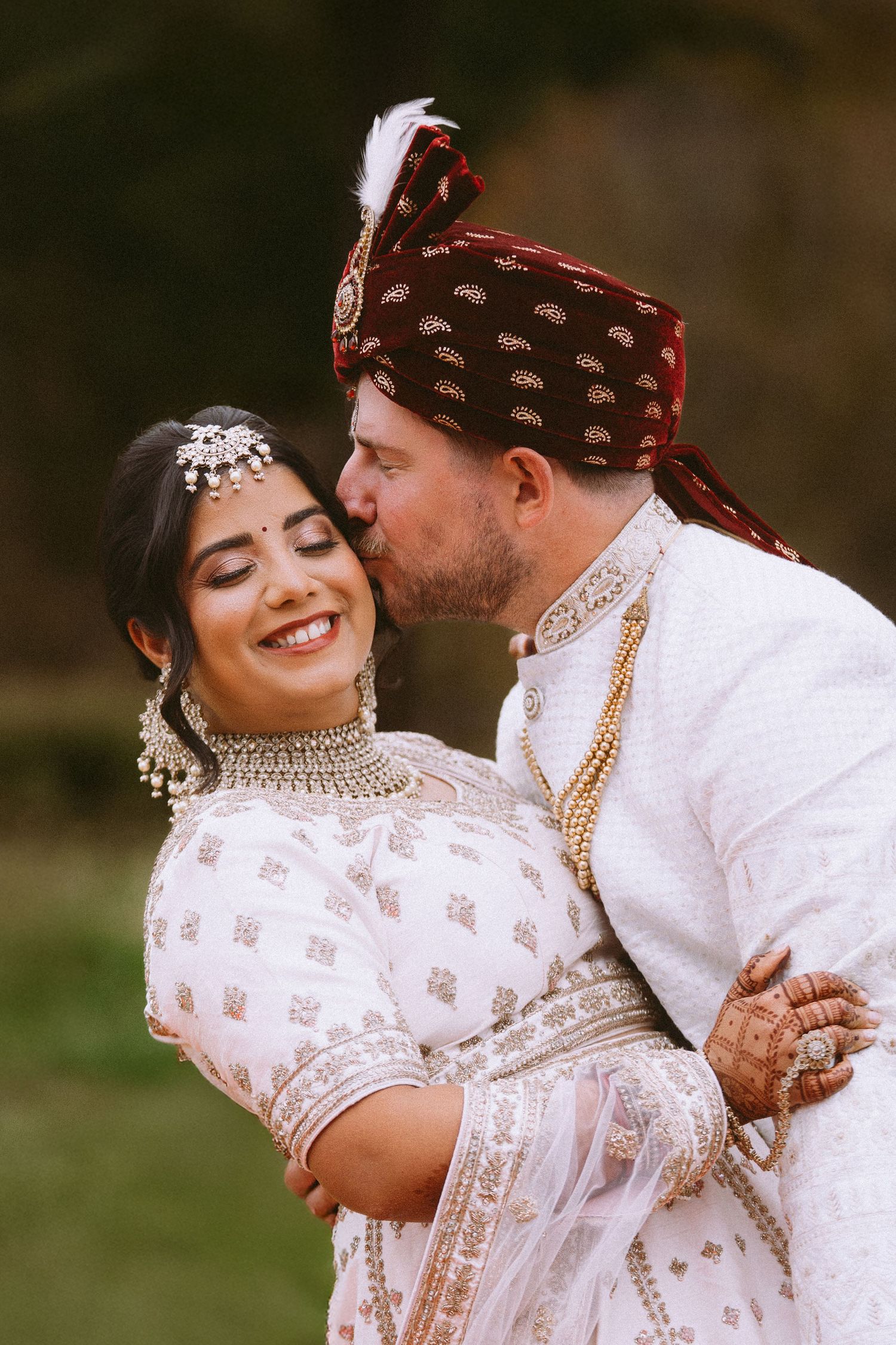 Intimate wedding portraits showing couple in white and burgundy traditional fusion attire.