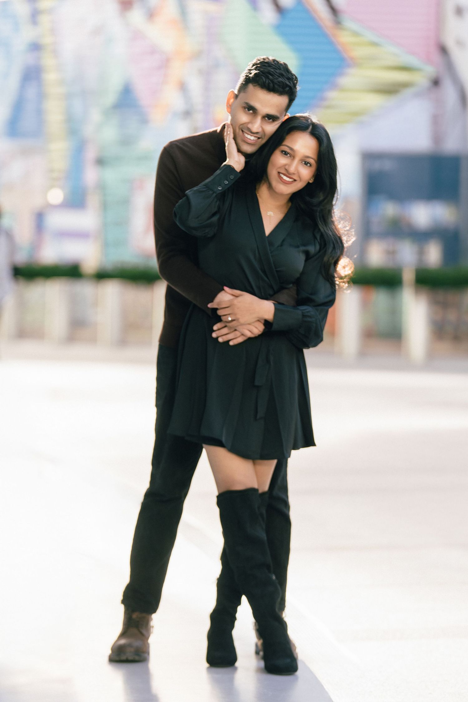 A couple in black outfits poses playfully together in a series of candid outdoor photos.
