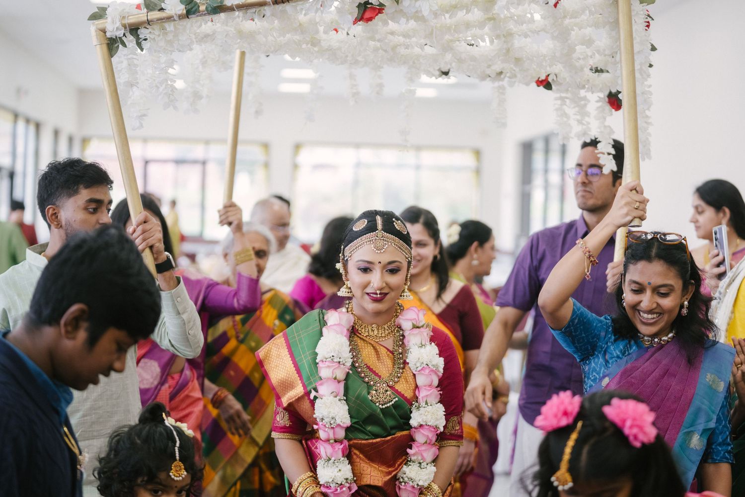 Festive wedding celebration with guests dancing and celebrating in colorful traditional attire.