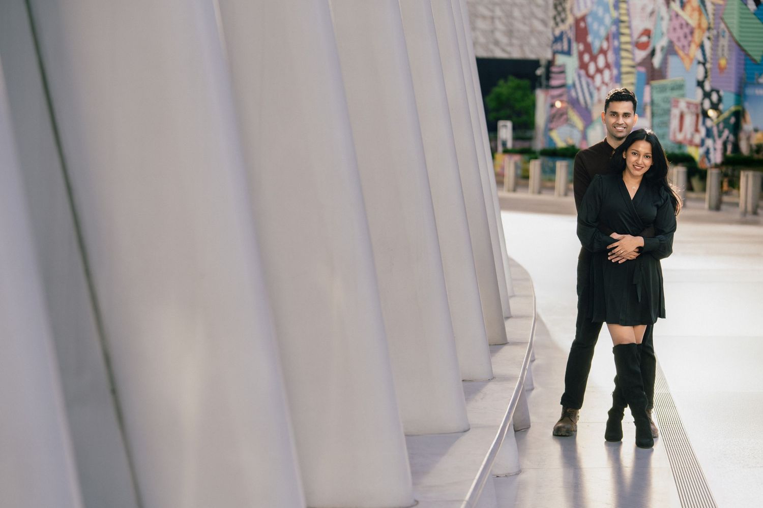 Models walk down a runway in dark formal attire during a fashion show presentation.