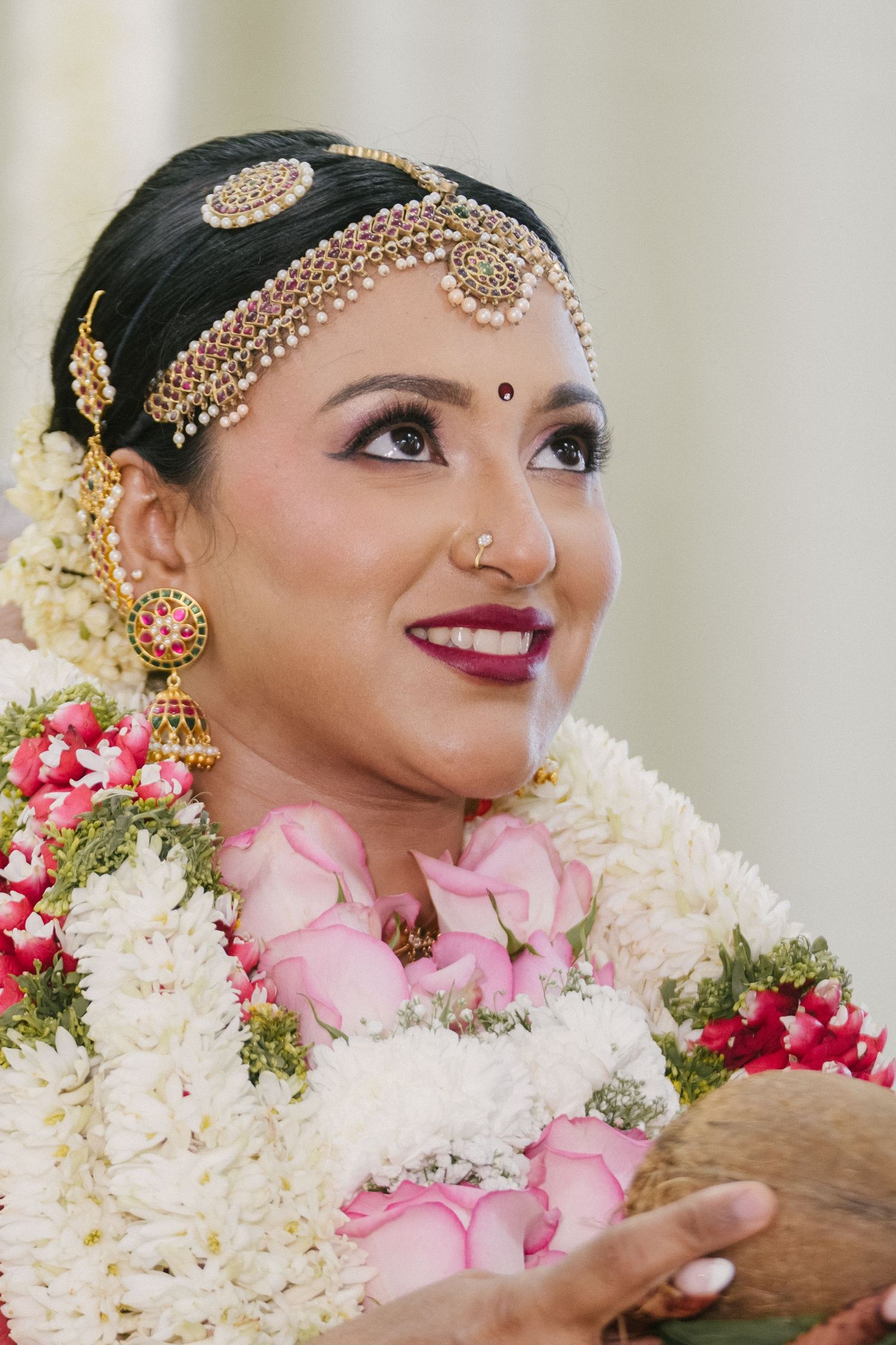 Traditional South Asian bridal look with ornate gold headpiece and floral garland.