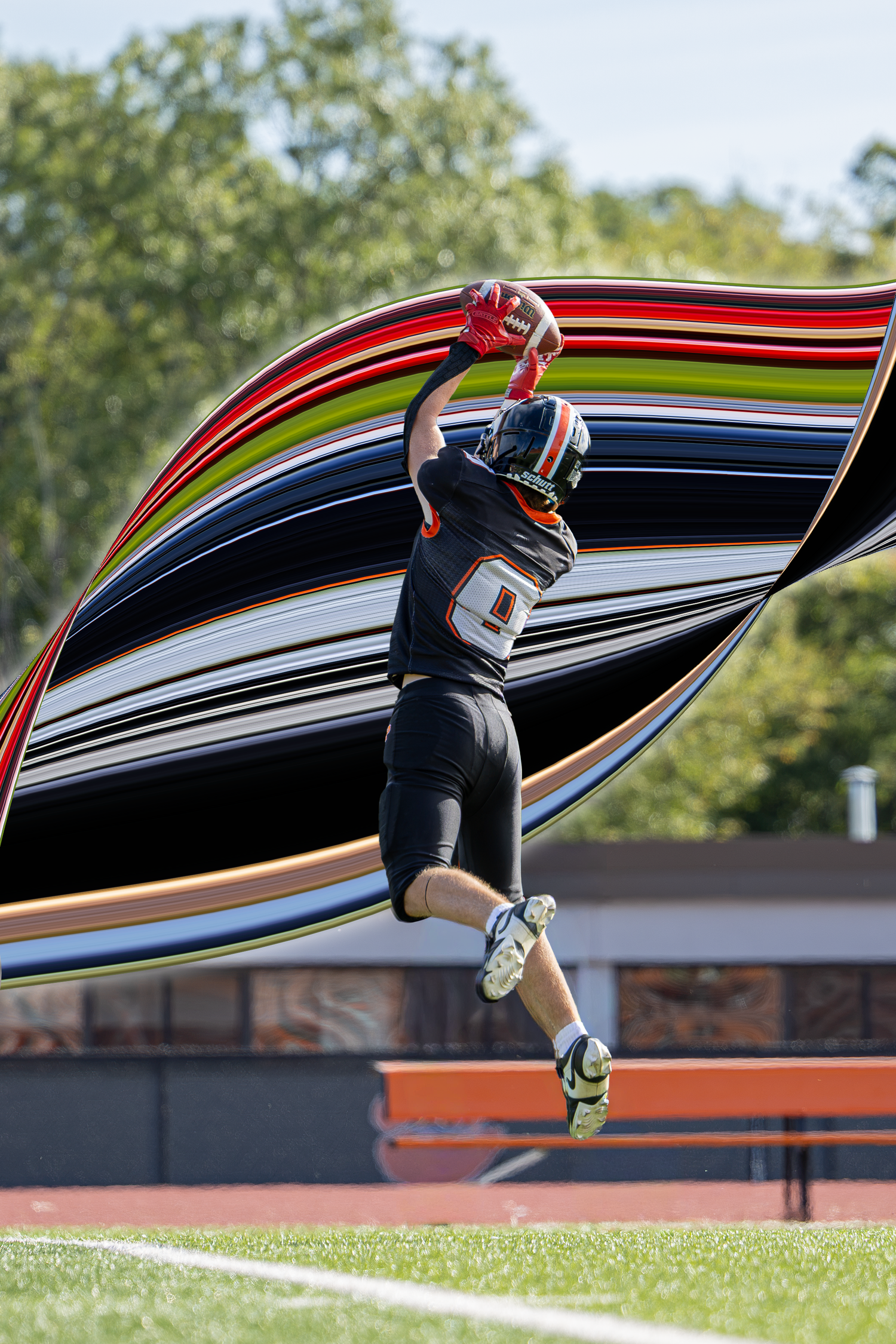 Football player in black and orange uniform leaps to catch a pass with motion blur effect.